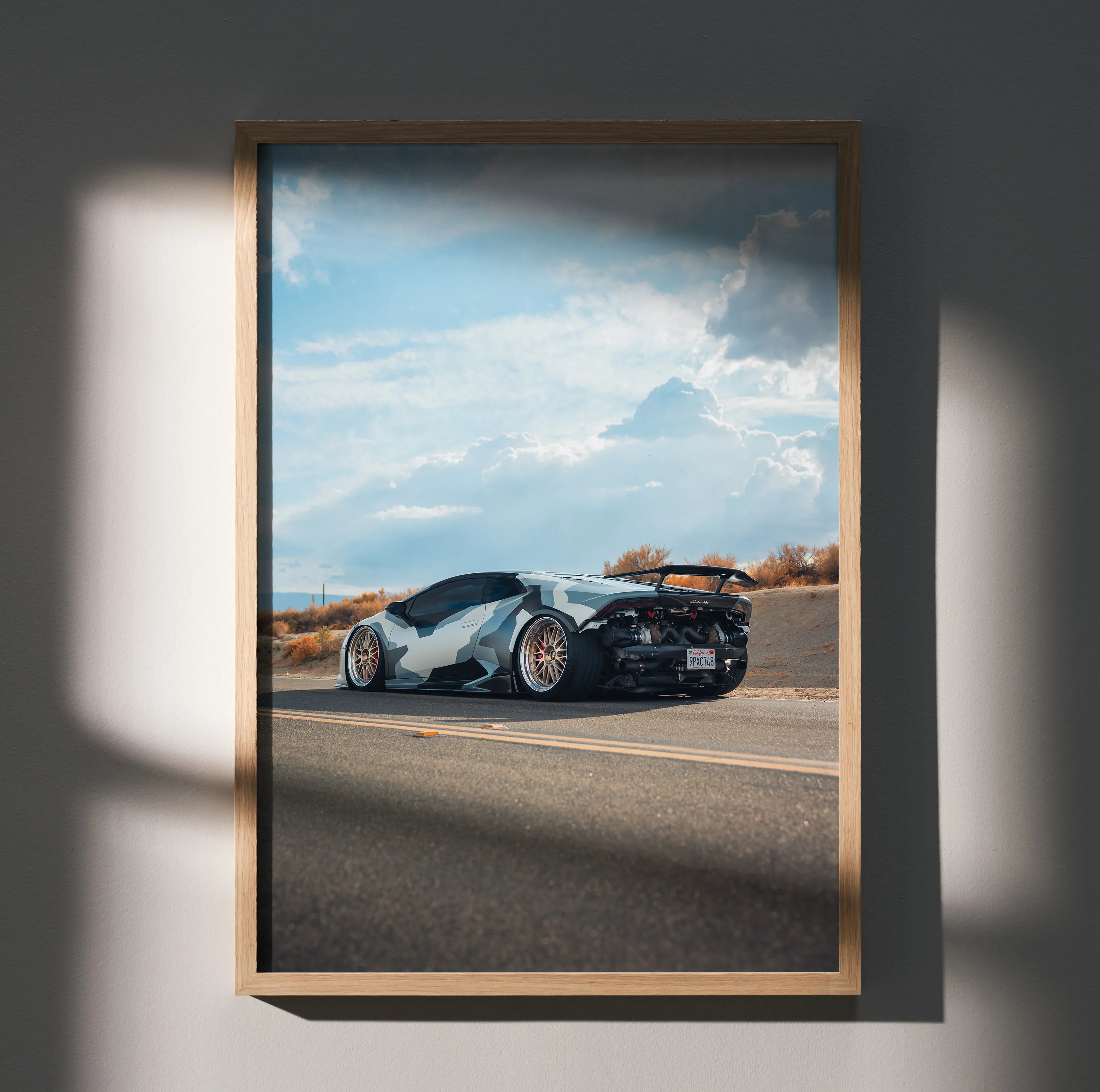 Lamborghini Huracan poster wall art with sleek white and black car on open road under blue sky.
