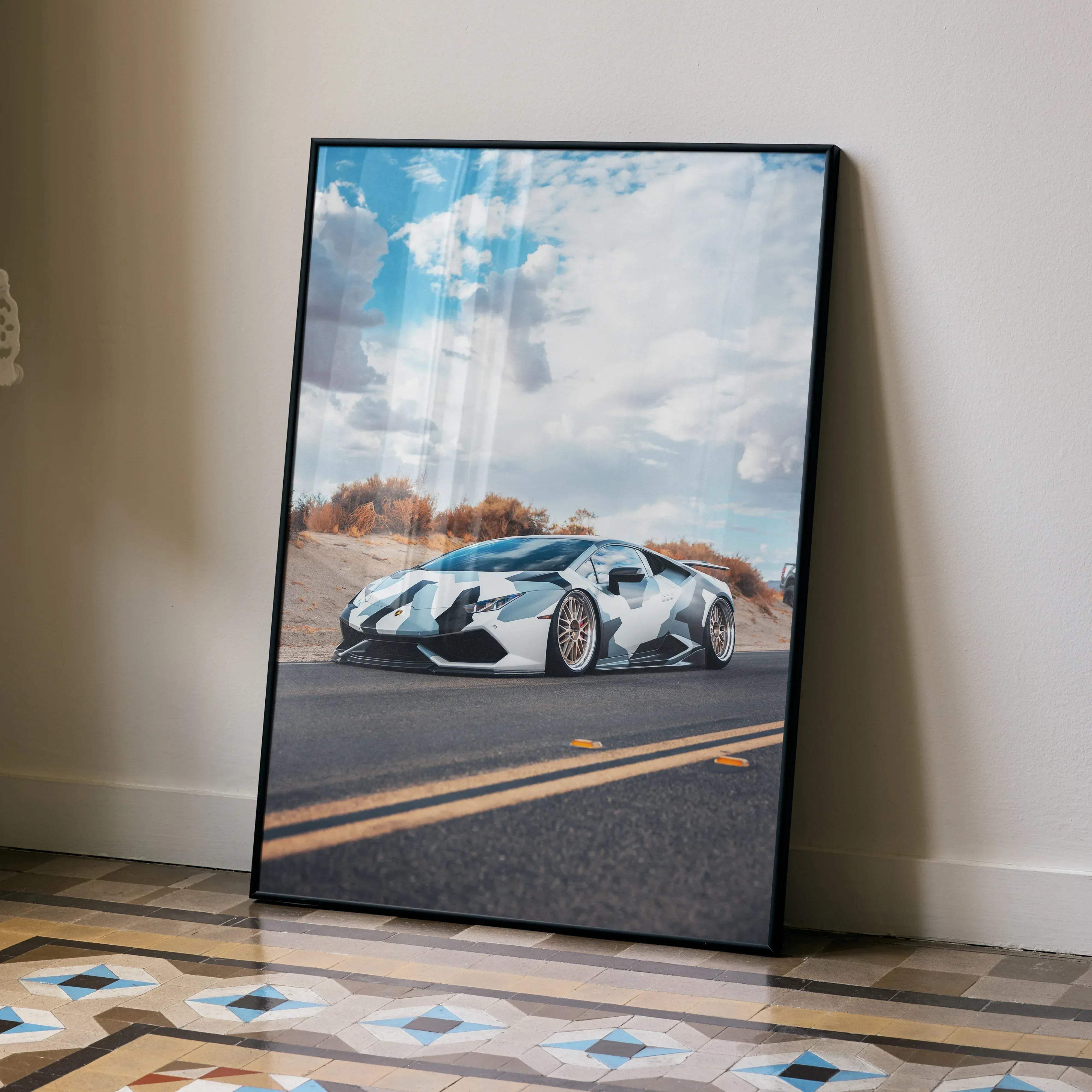 Black-framed canvas print of white and black camouflage lamborghini huracán on asphalt road under cloudy sky car poster
