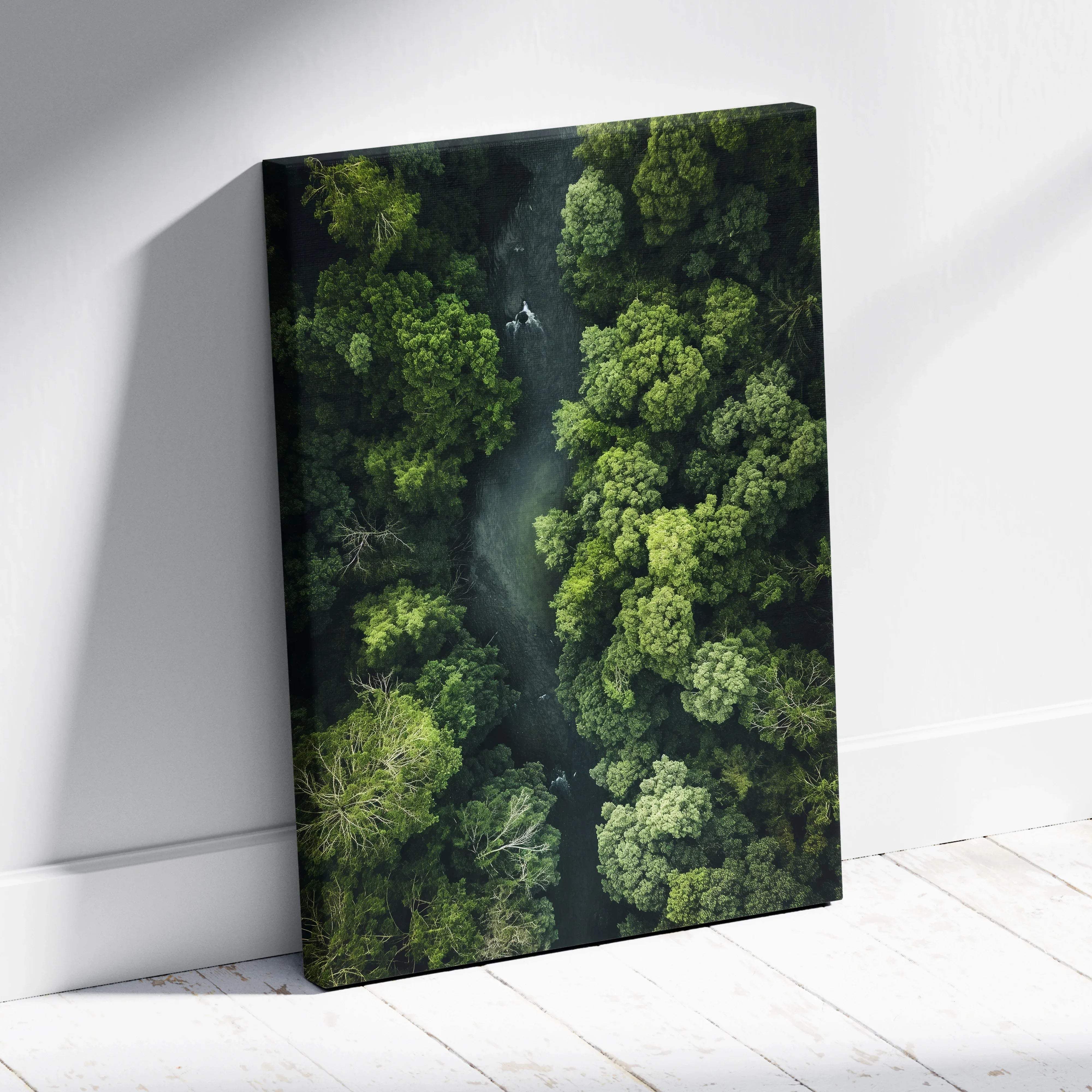 Aerial forest canvas wall art featuring lush green trees and a winding river displayed on a white wall