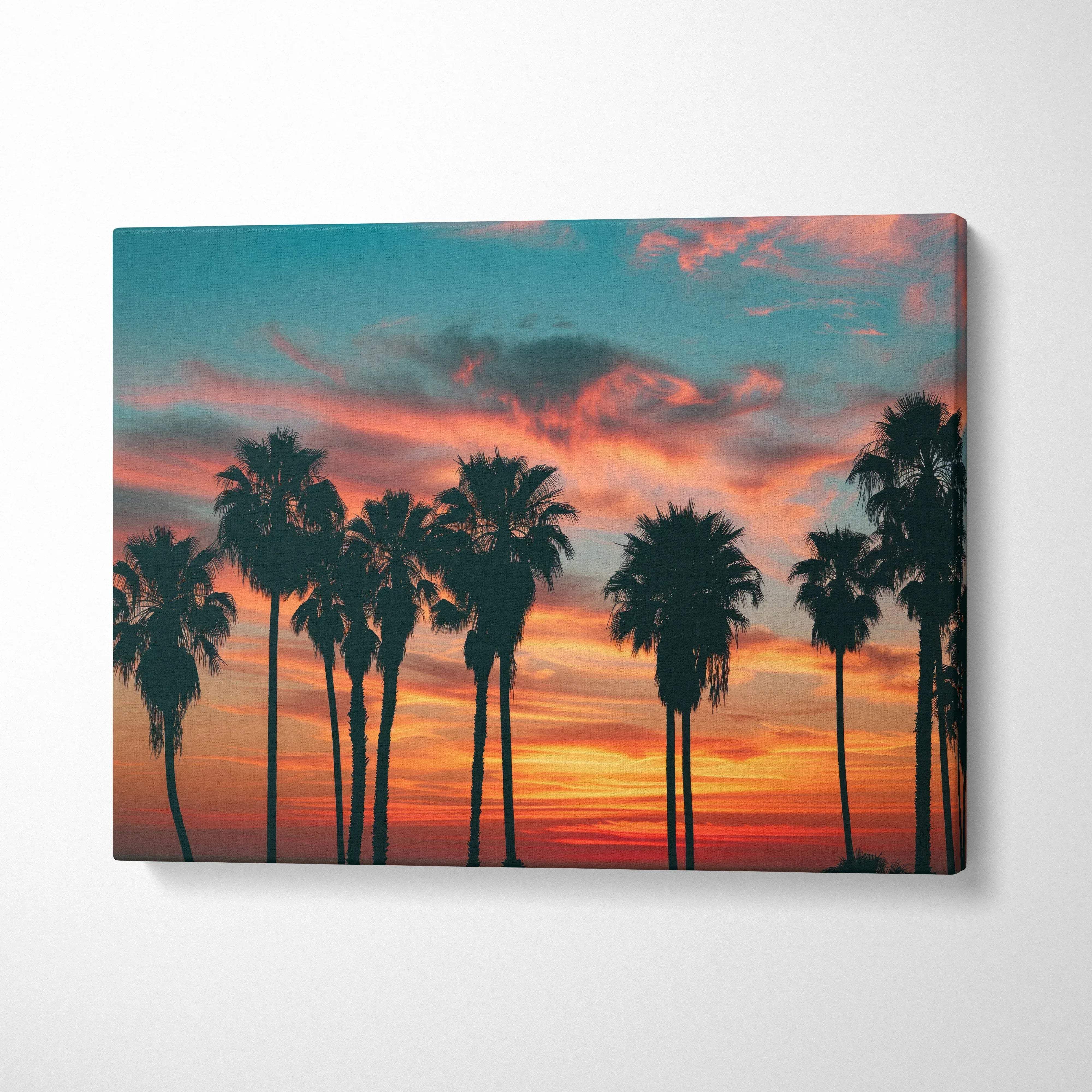 Canvas wall art featuring black palm tree silhouettes against a vibrant tropical sunset sky for home decor.