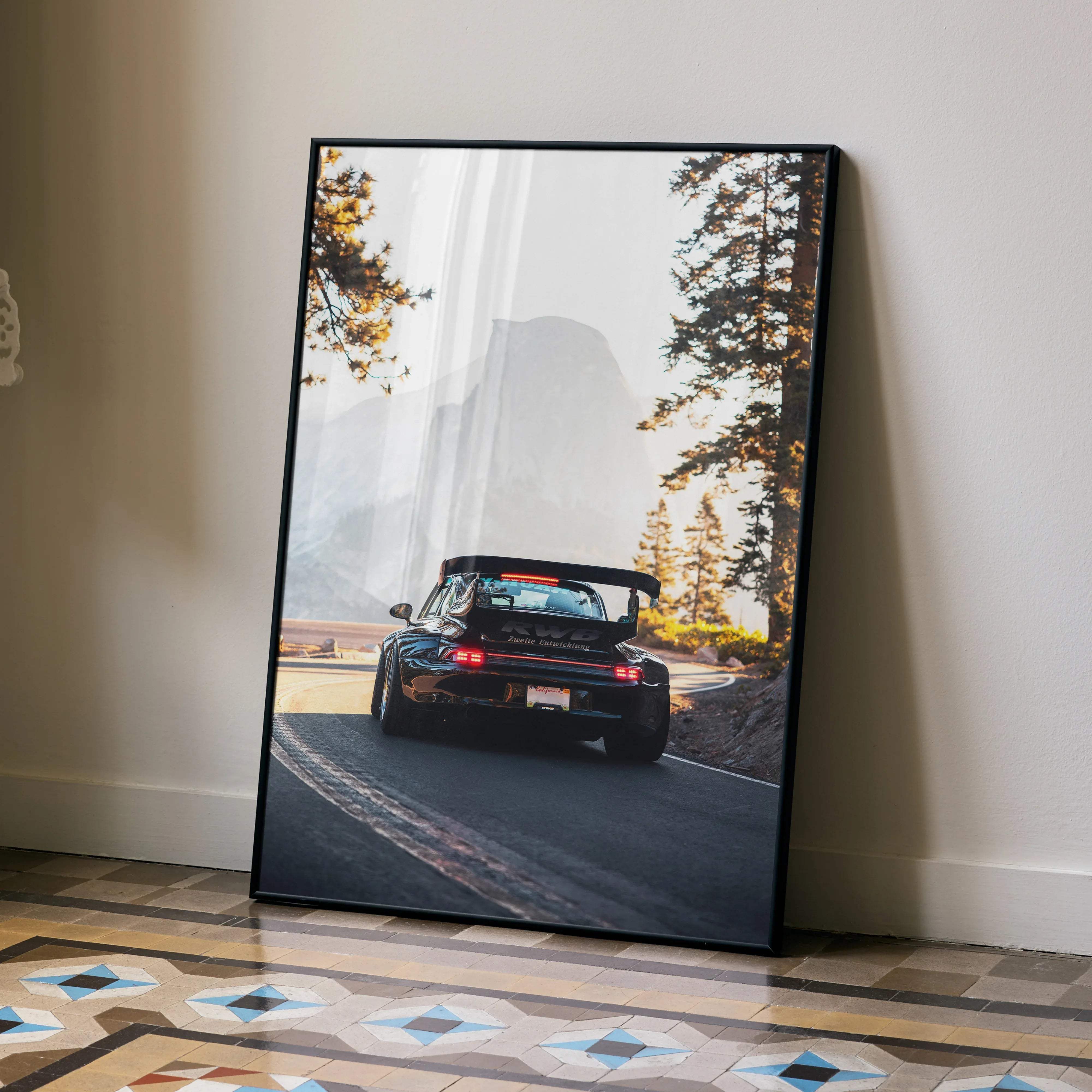 Black framed poster of a porsche 911 gt3 rs with red taillights on a winding road in misty mountains for car lovers