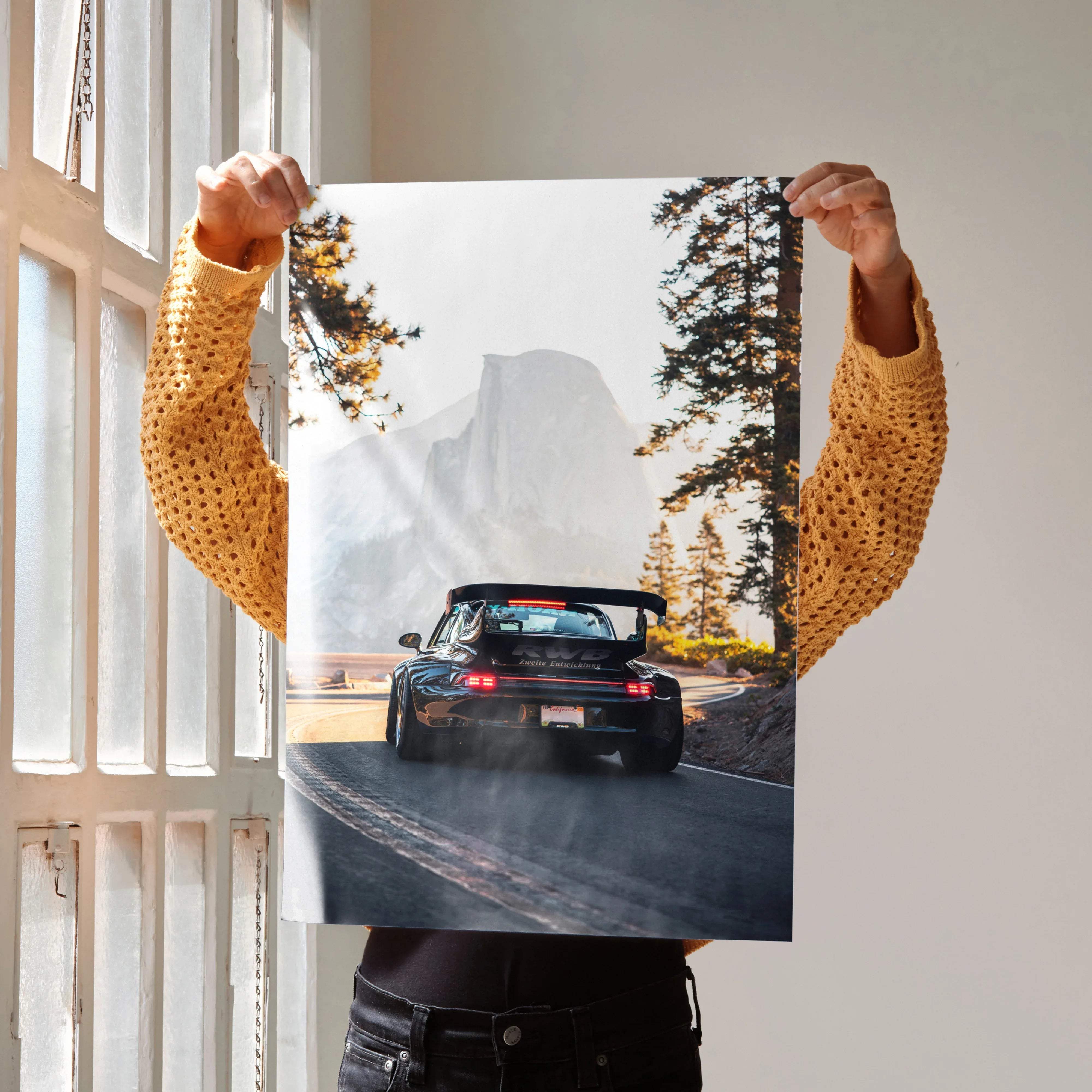 A glossy black porsche 911 carrera rs rear view art print with brake lights on against misty mountains and pines