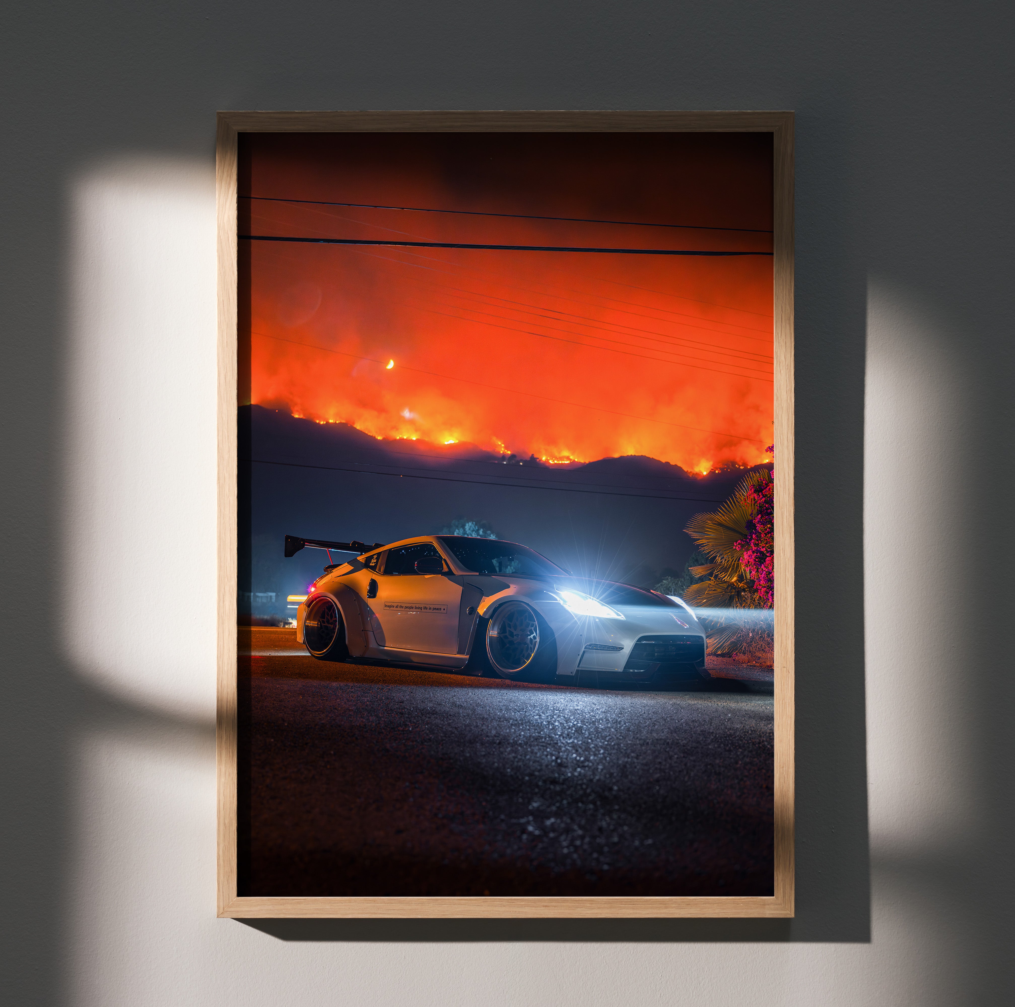 Nissan 370z poster wall art with glowing headlights against fiery orange night sky background.