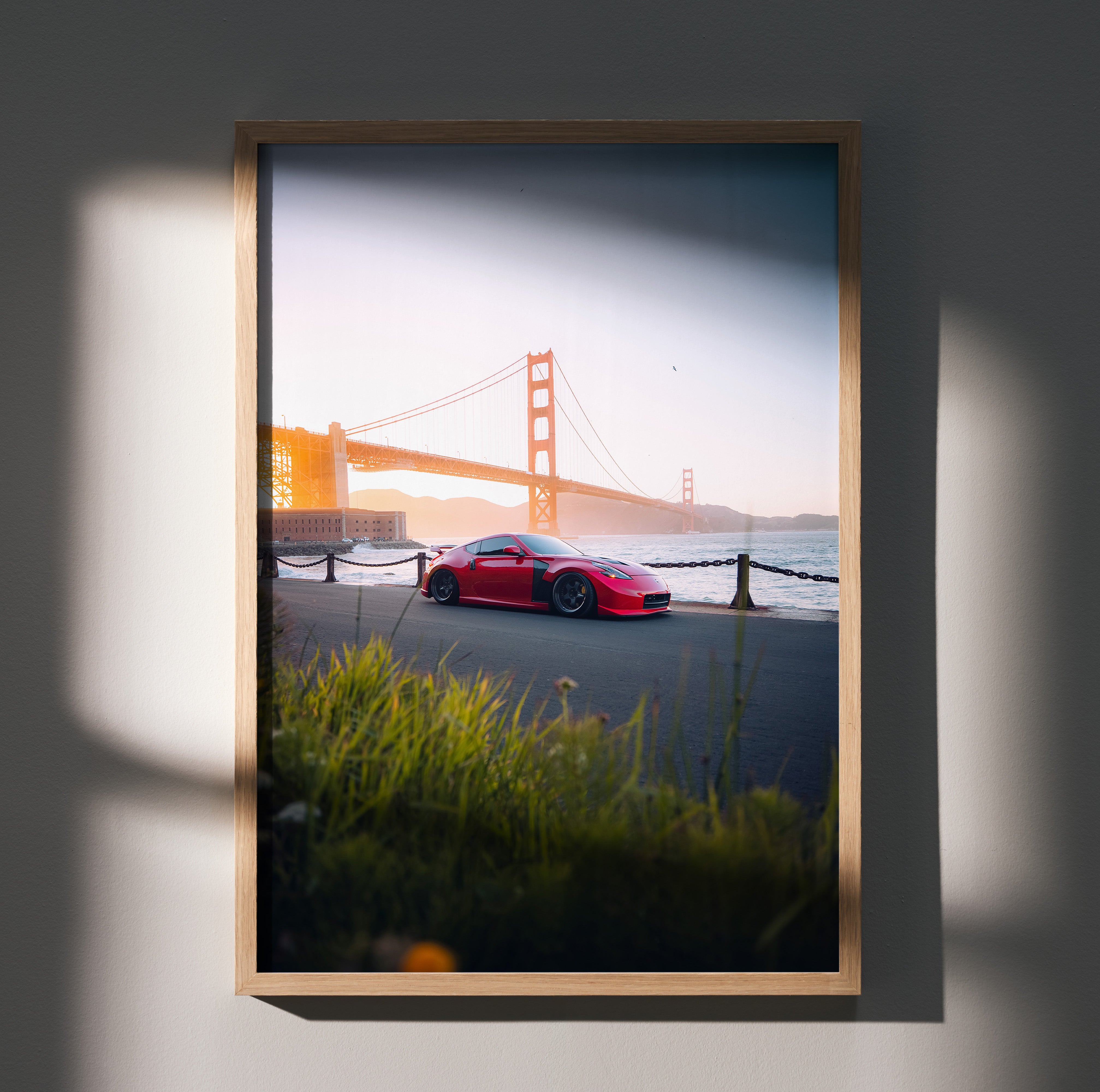 Nissan 370z parked near Golden Gate Bridge at sunset poster wall art with vibrant colors.