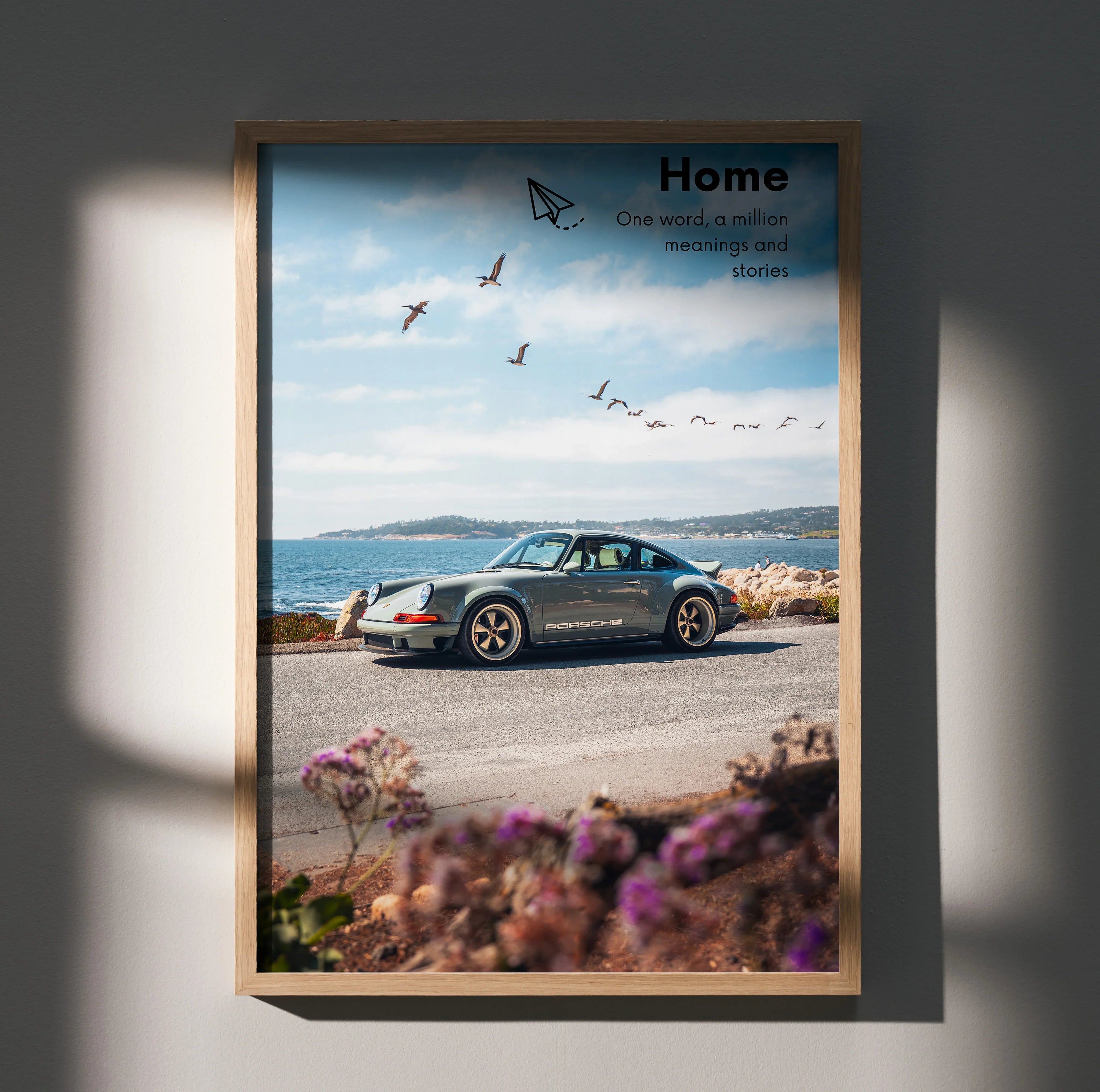 Motivational wall art poster featuring a classic Porsche 911 by a seaside road under a blue sky with birds flying.