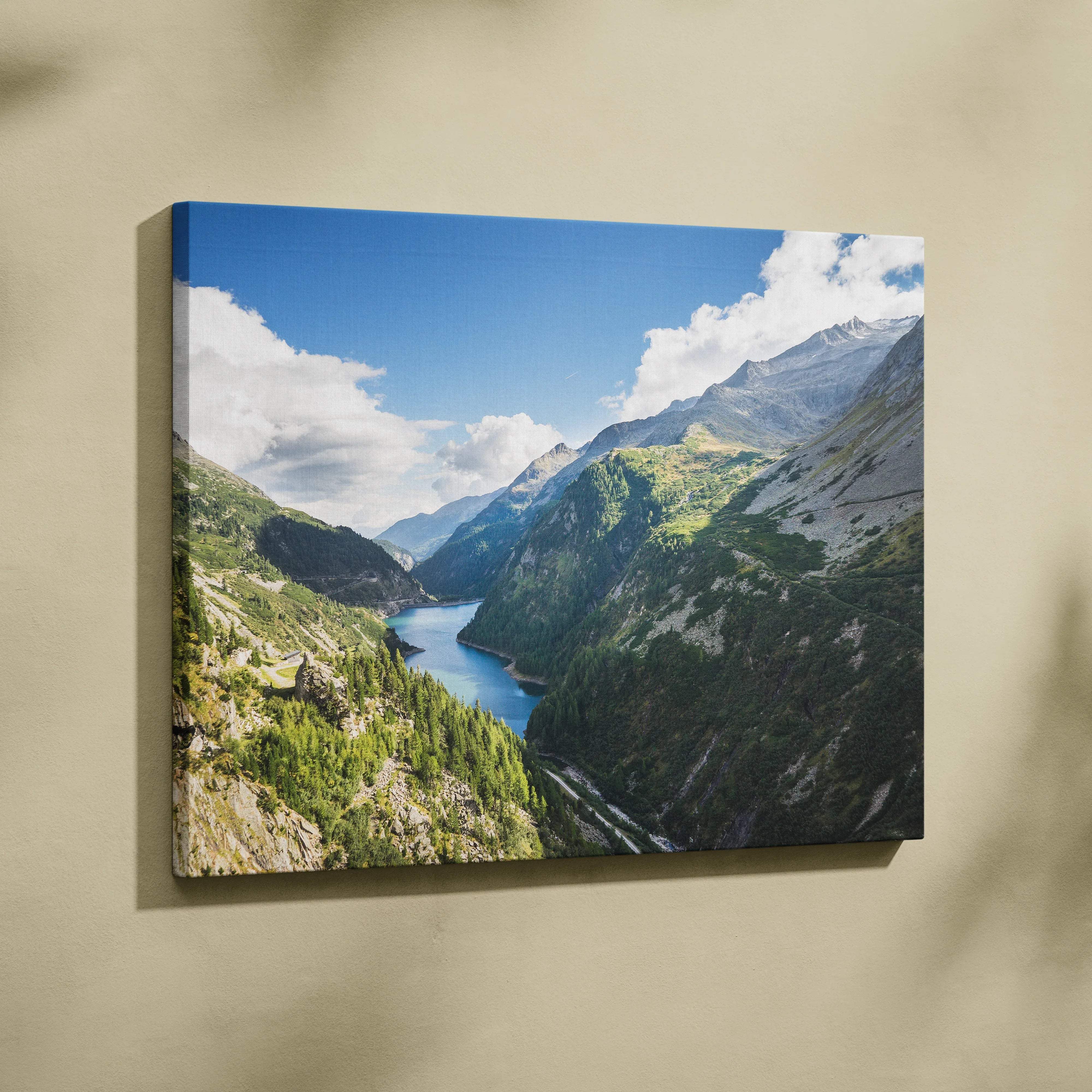 Canvas print of serene lake between snow-capped mountains, lush valleys, blue sky