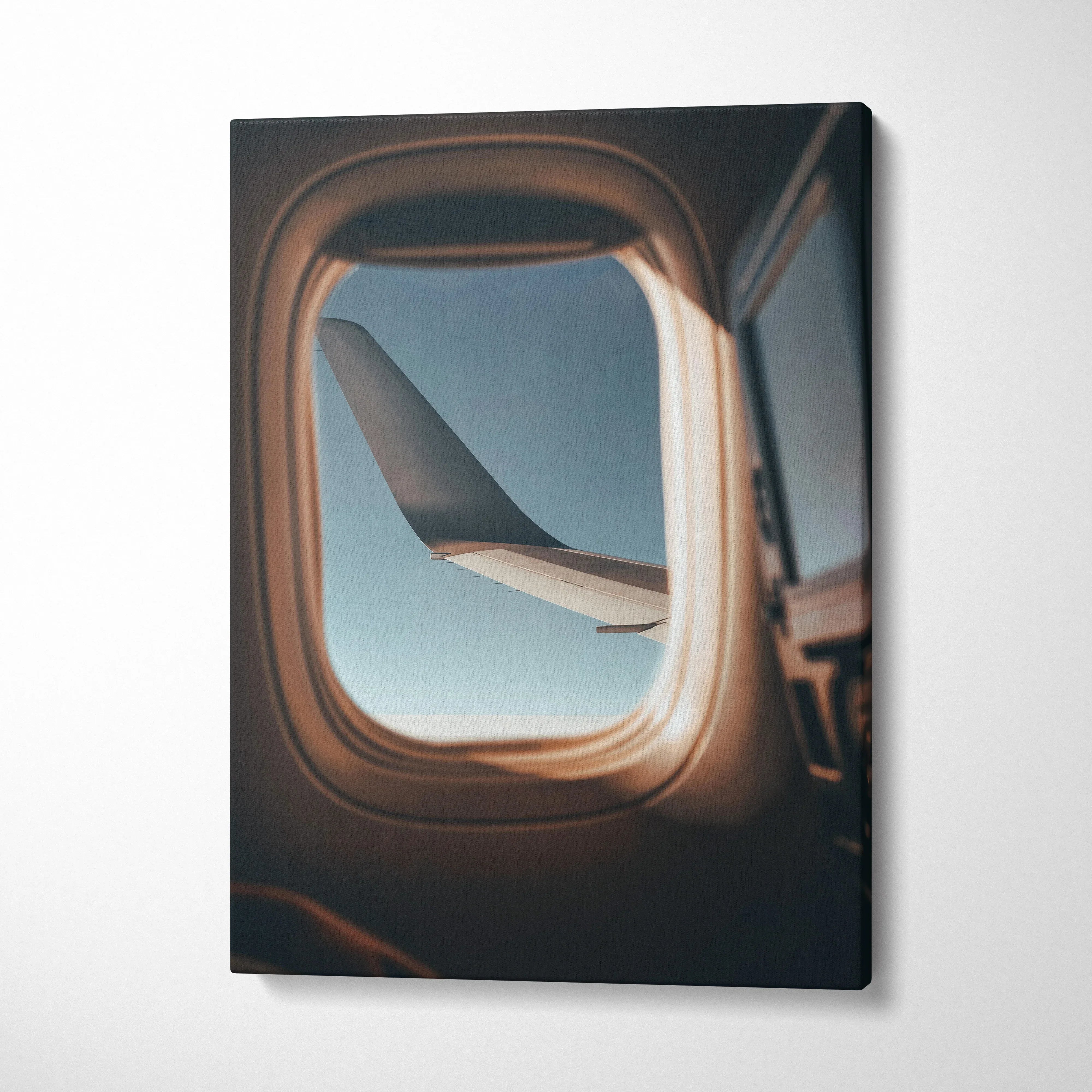 Canvas wall art featuring an airplane wing viewed through an aircraft window with soft natural lighting.