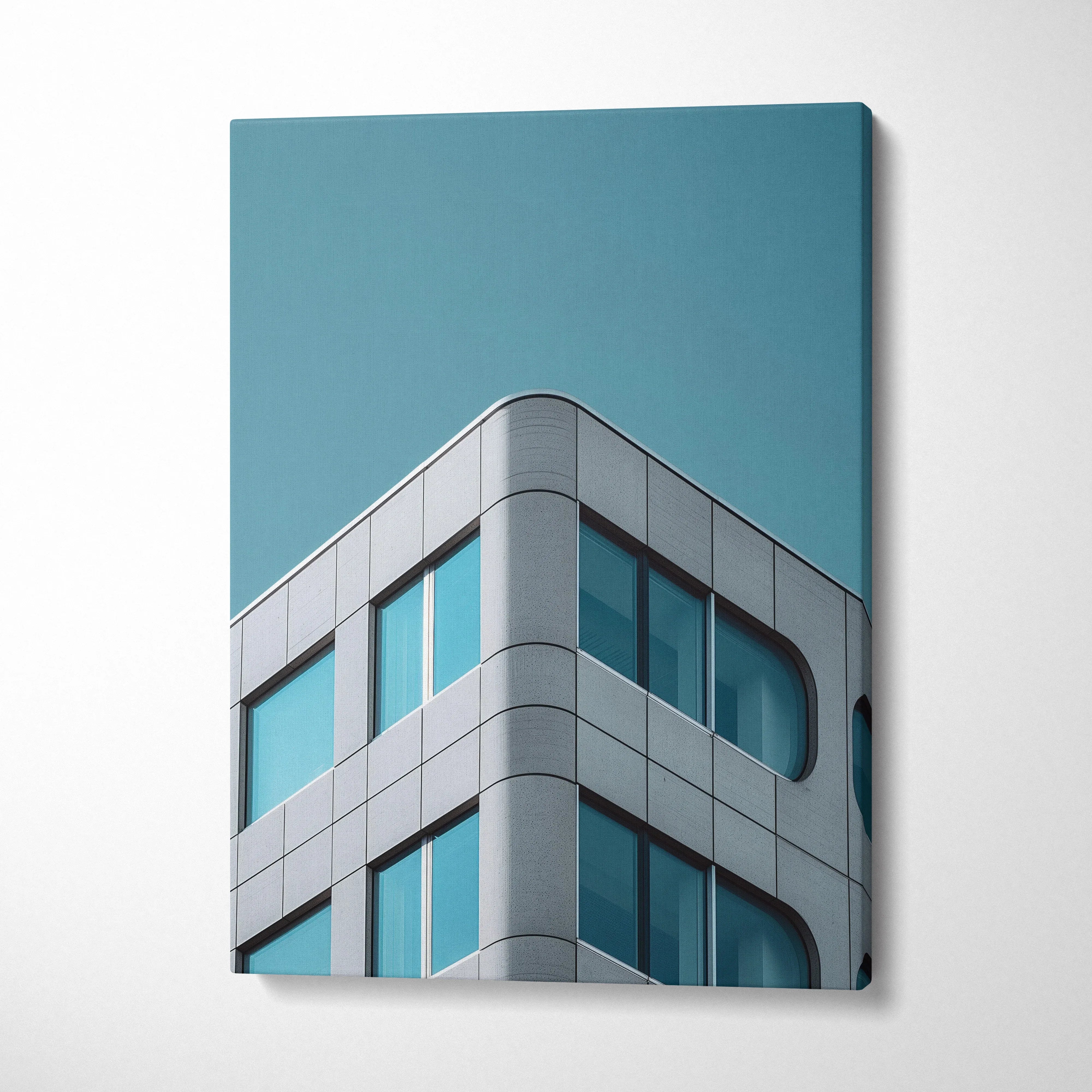Modern building corner with curved glass windows on blue sky canvas wall art.