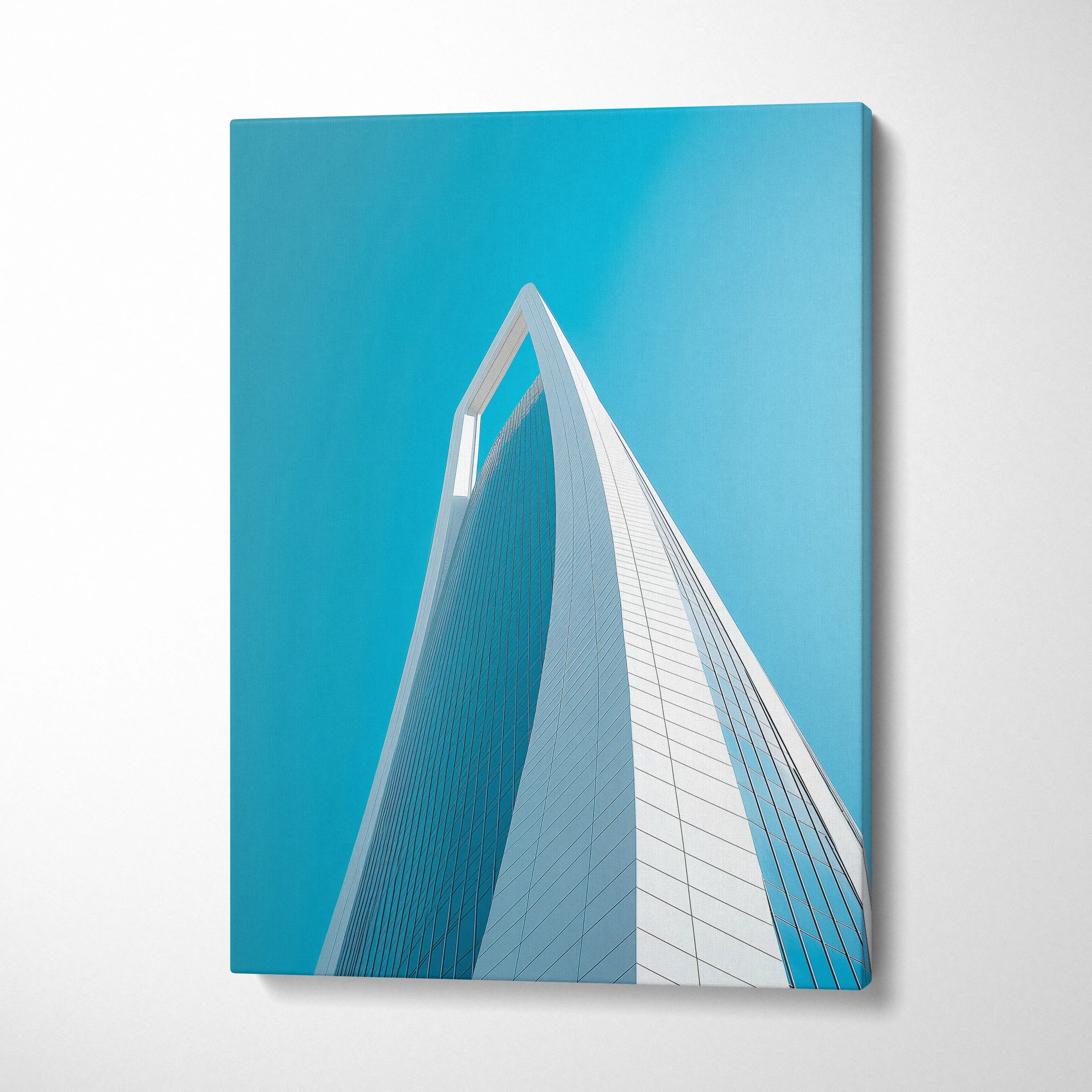 Modern white architectural building with dramatic upward angle on bright blue sky canvas wall art.