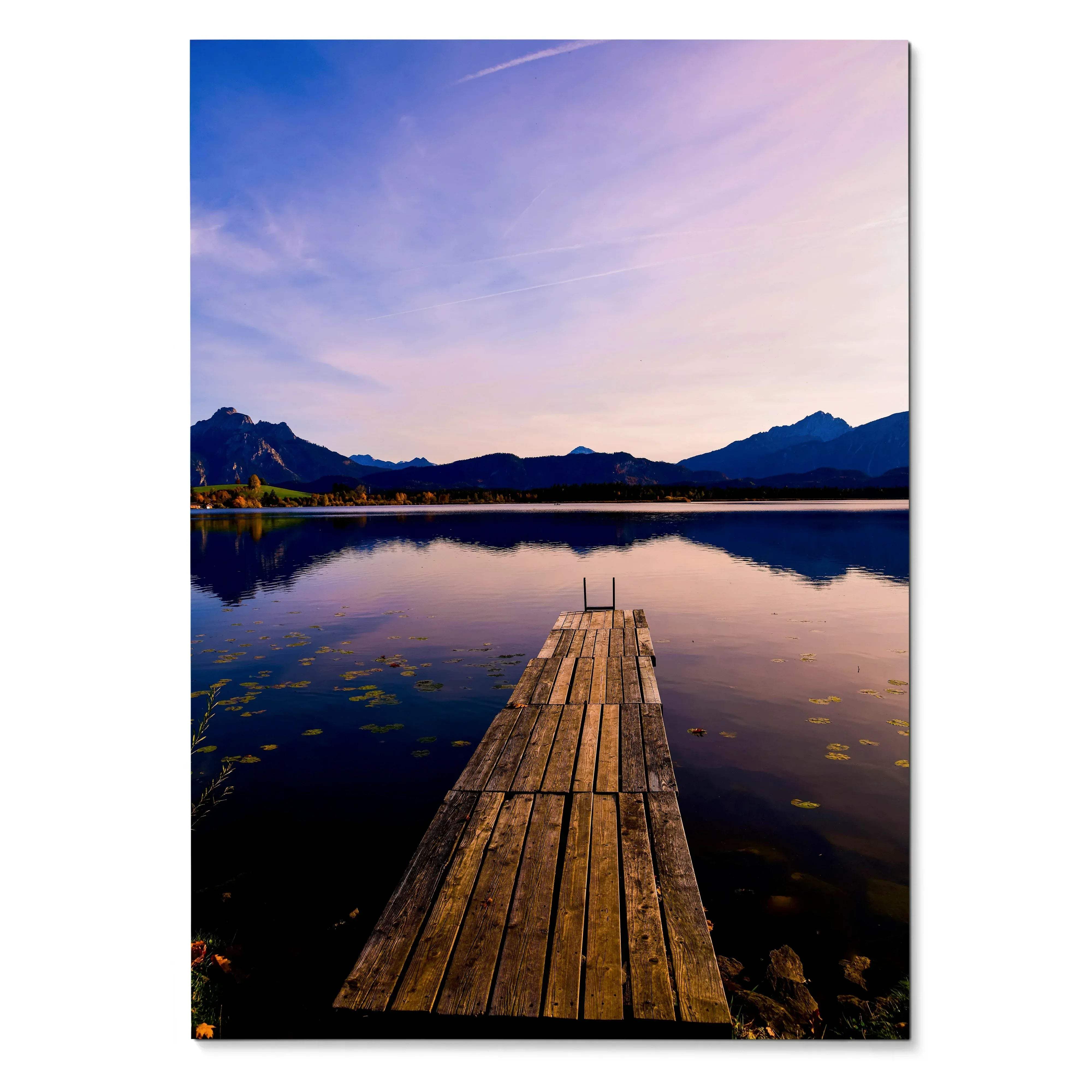 Vertical wall art poster of wooden dock extending into calm lake with mountain silhouettes at sunset.