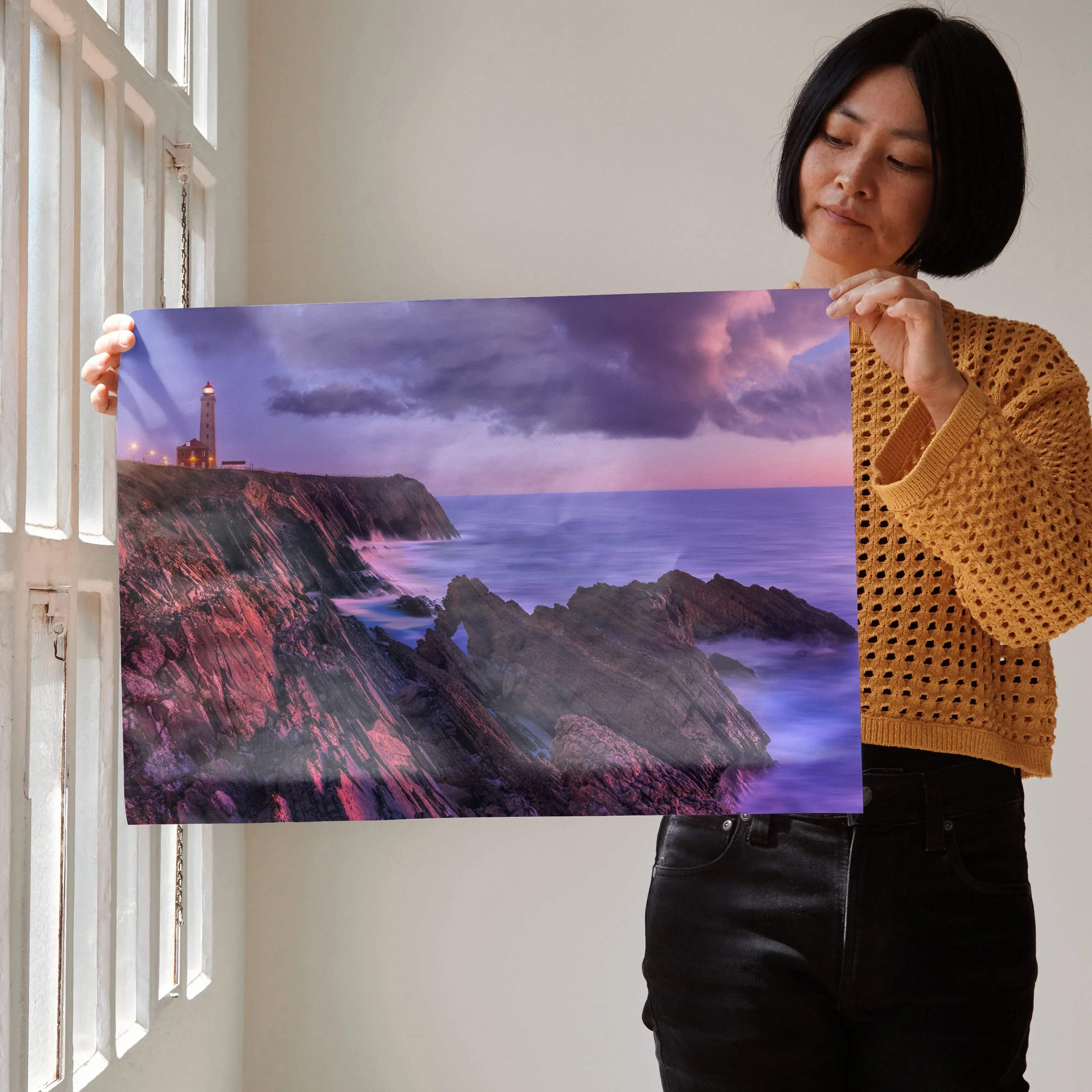 Rectangular art poster featuring a dramatic lighthouse on rugged cliffs at sunset with purple and pink twilight sky