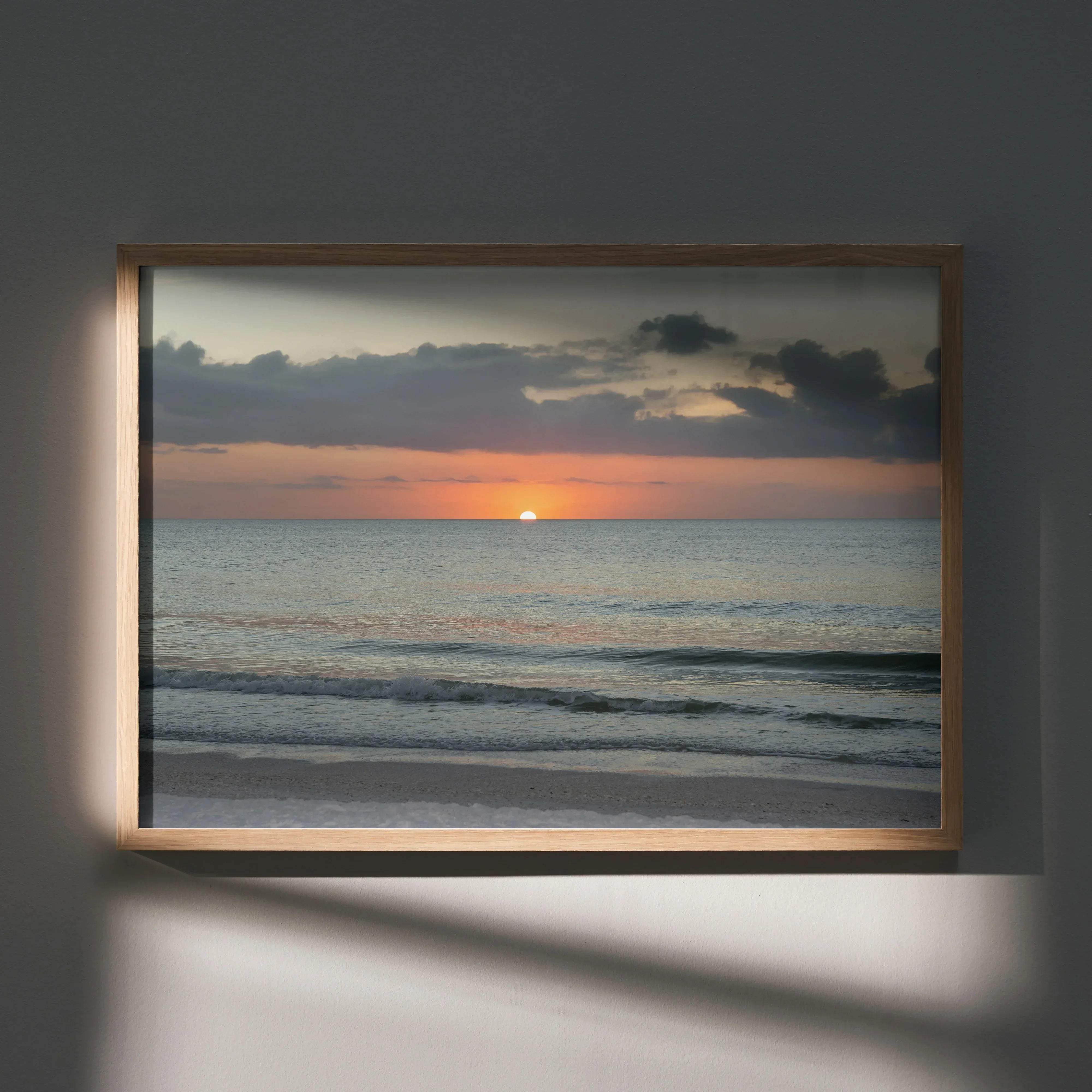 A rectangular wooden-framed beach sunset nature art poster featuring a serene orange and gray ocean sunset for wall decor
