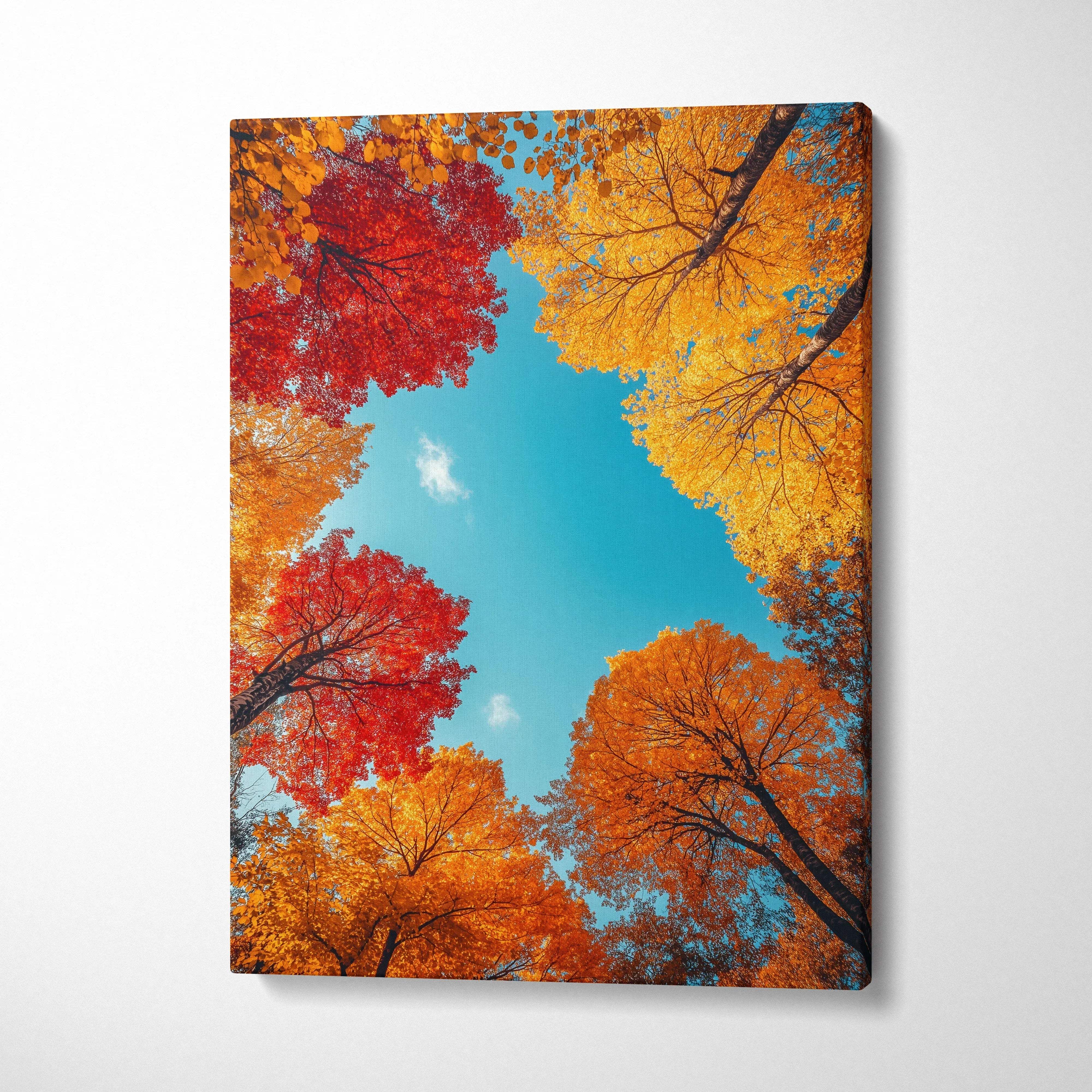 Vertical canvas wall art featuring vibrant autumn leaves in red, orange, and yellow against a bright blue sky.