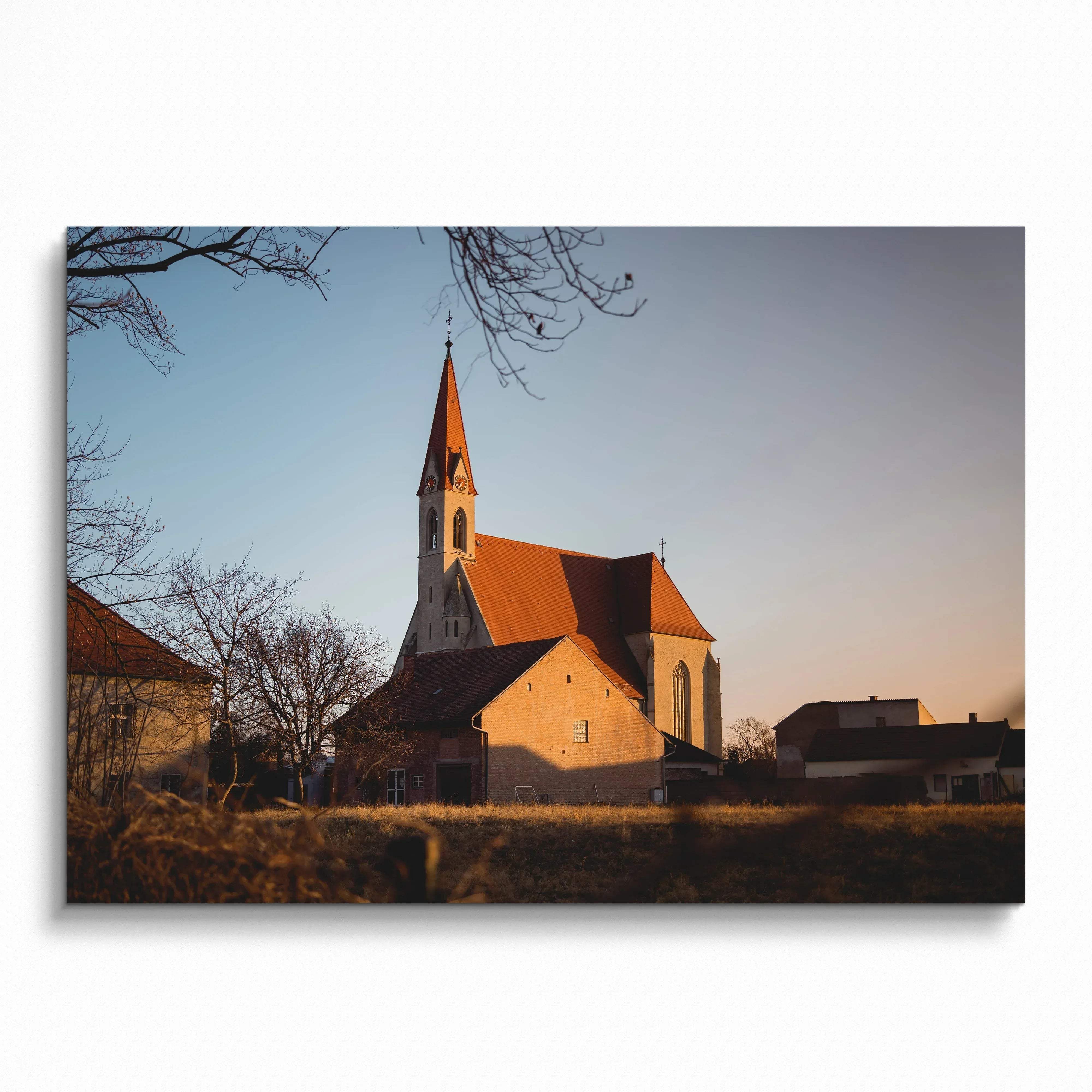 Church with tall steeple at sunset surrounded by trees, serene landscape wall art poster.
