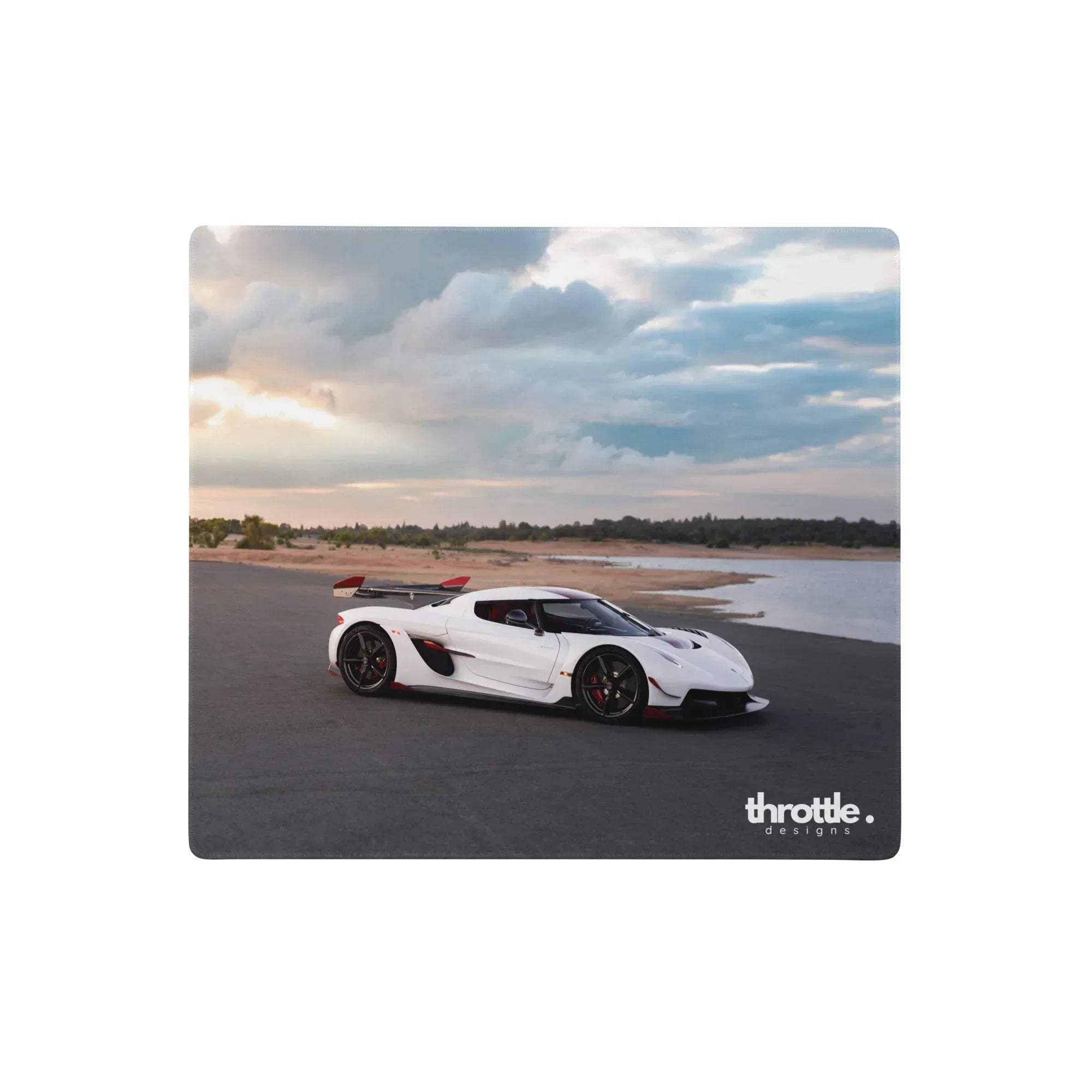 White koenigsegg jesko hypercar with red accents on a large rectangular gaming mouse pad with black wheels