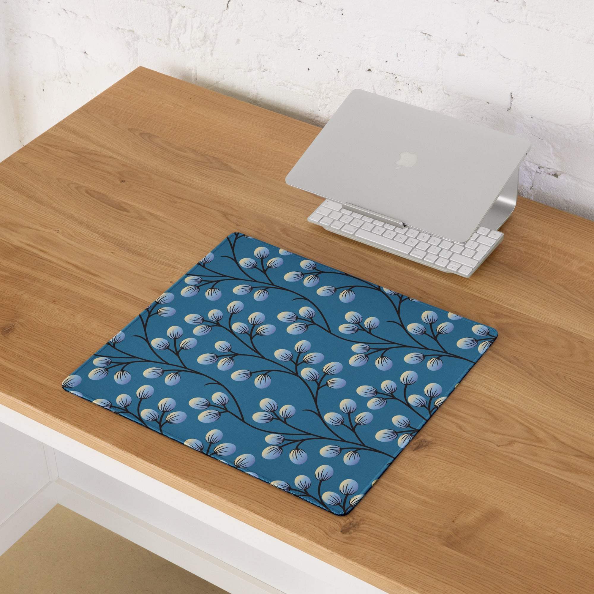 Elegant floral branches on deep blue gaming mouse pad with black branches and light blue buds