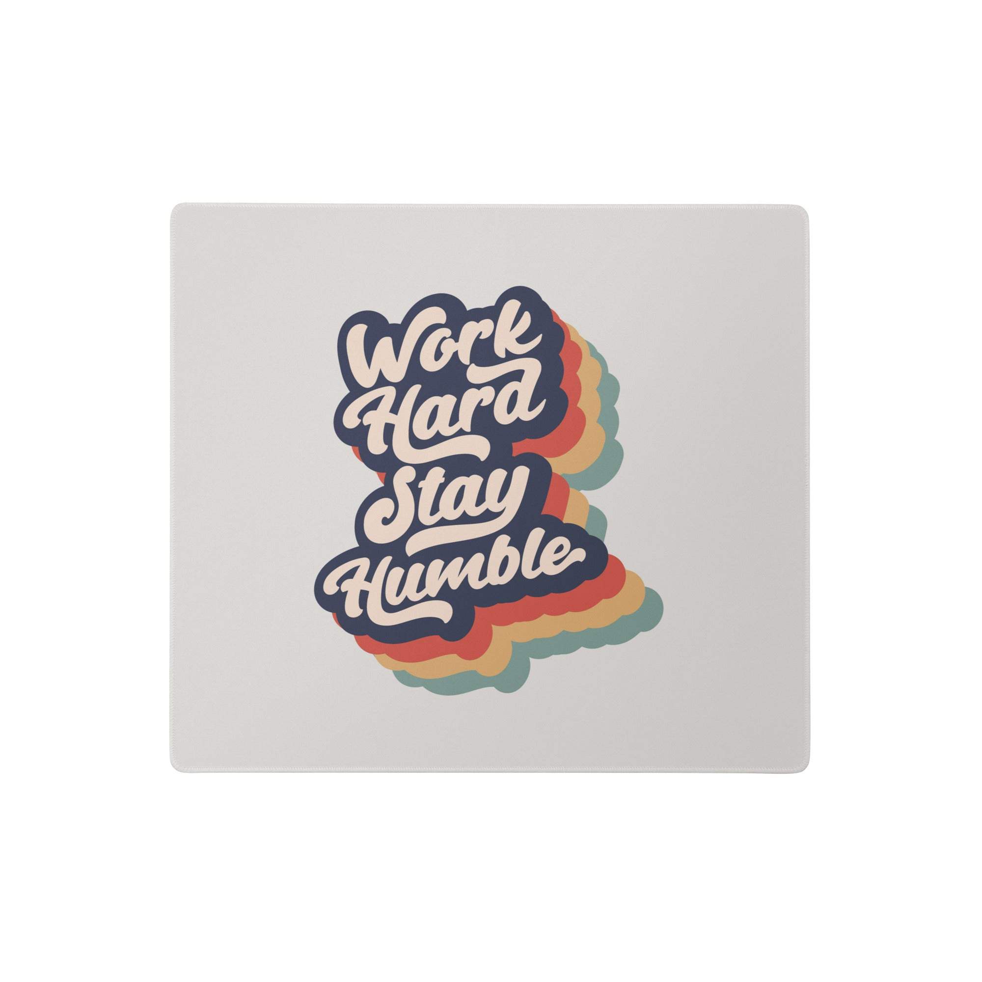 A light gray fabric mouse pad with a retro rainbow outline work hard stay humble design for modern office decor