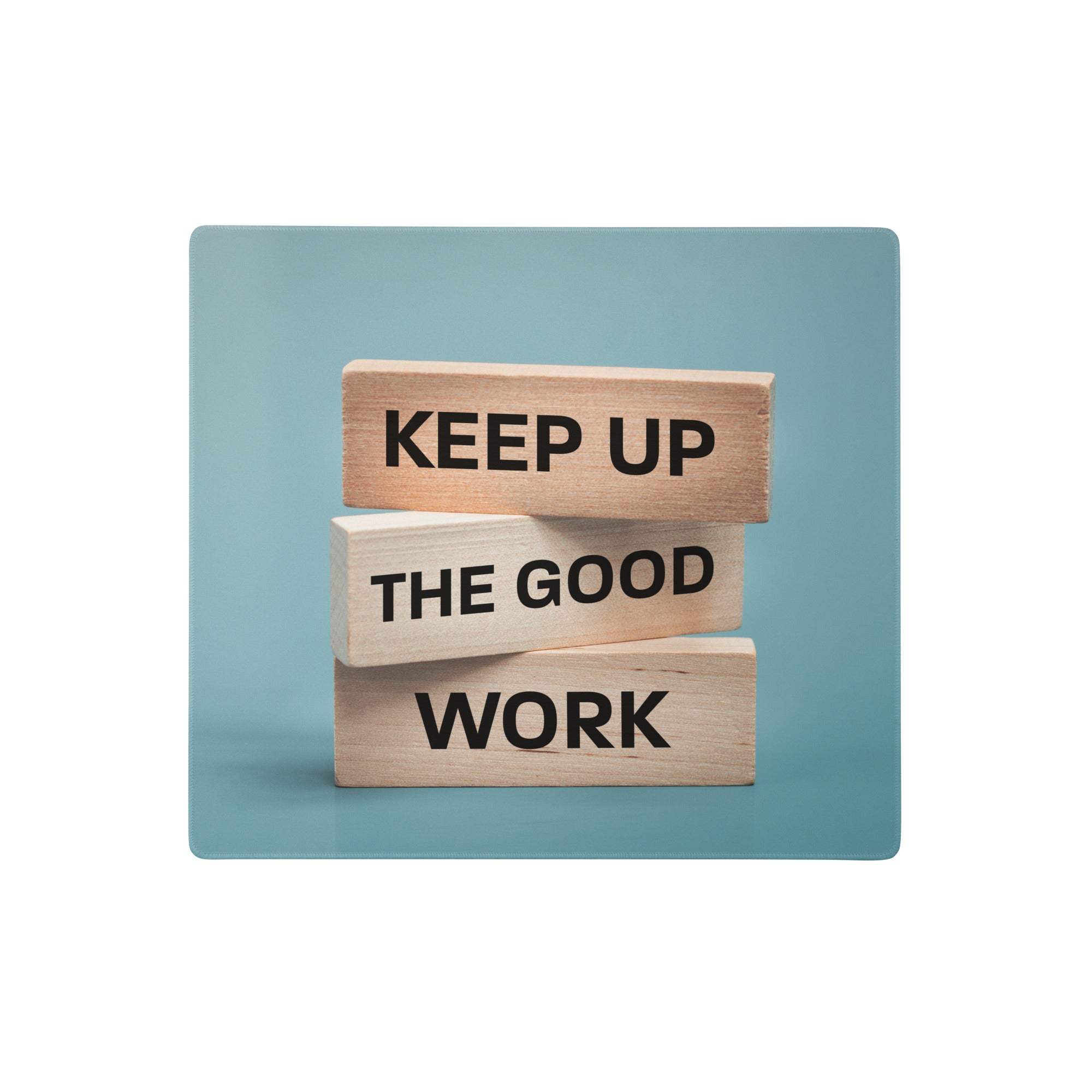 A blue mint mouse pad featuring three light wooden blocks engraved with keep up the good work for modern office decor