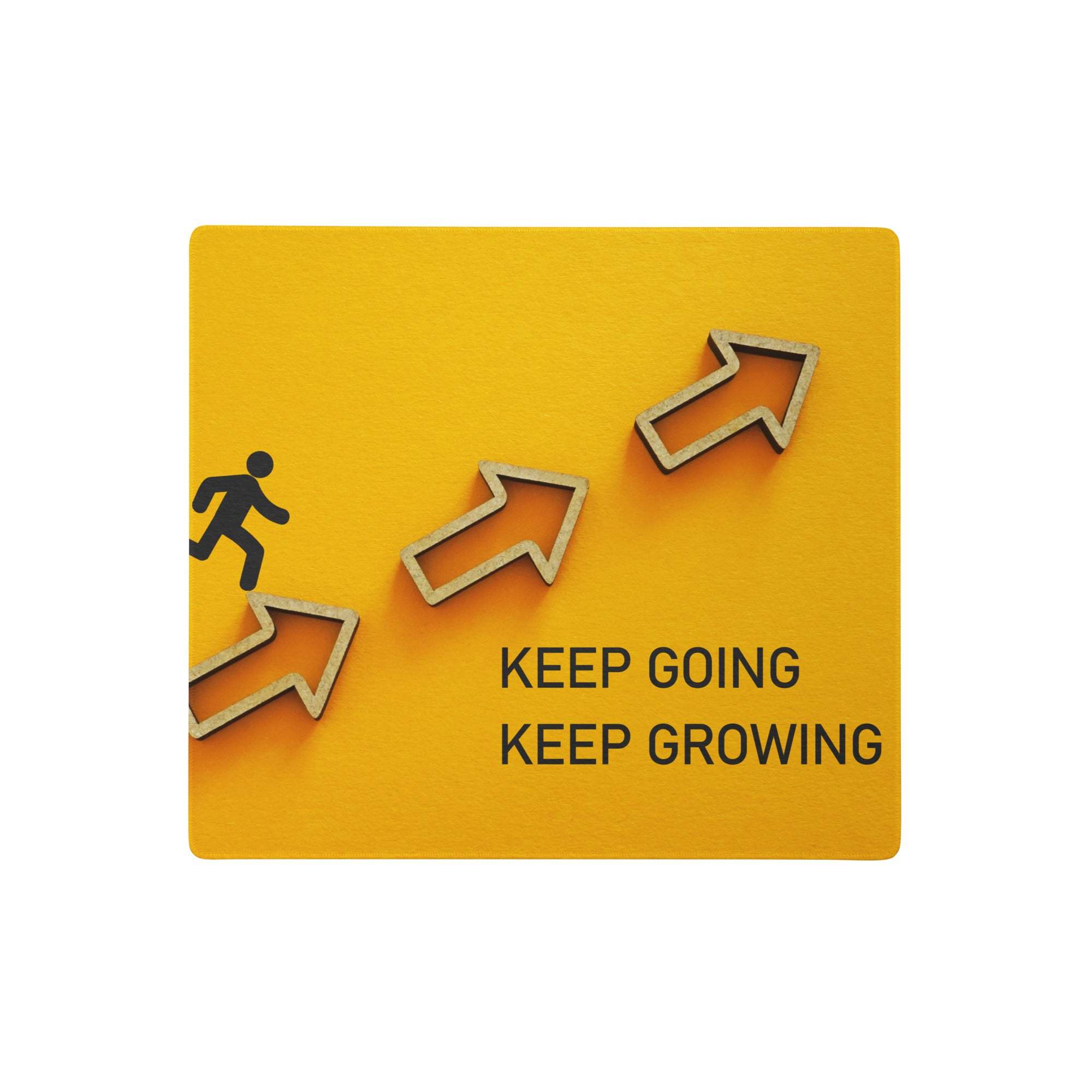 Yellow motivational mouse pad with black keep going keep growing text and three wooden arrows for home office desk