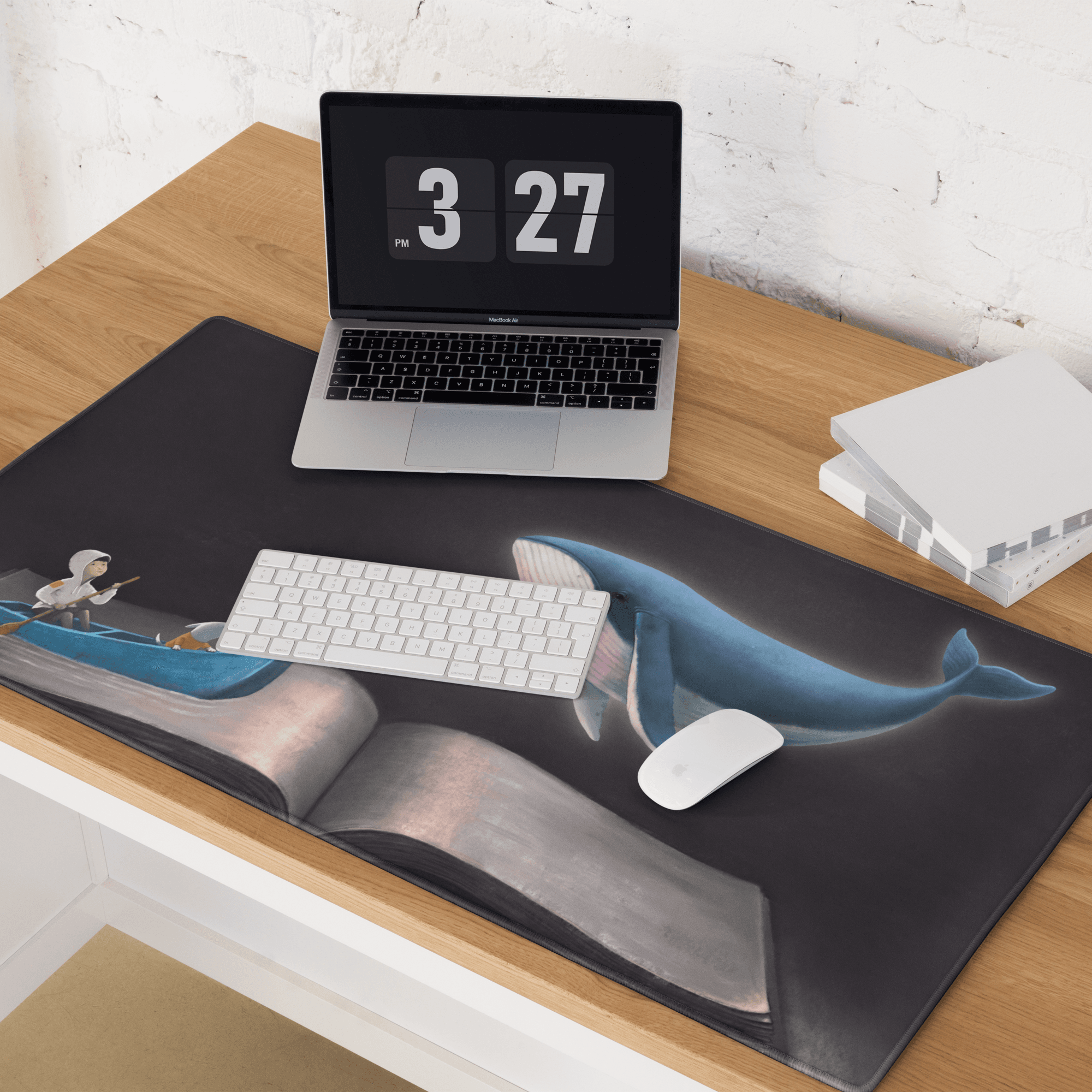 Black mousepad featuring a blue whale emerging from an open book with a small boat figure in nautical art style