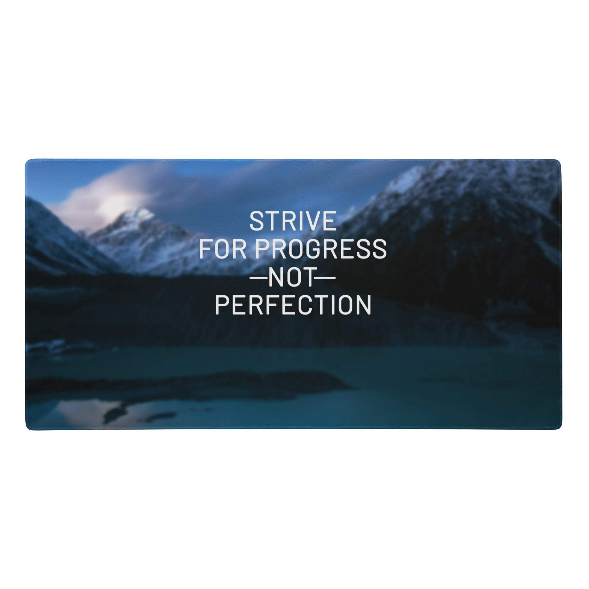 Rectangular blue mountain desk pad with serene lake scene and white text strive for progress not perfection digital print