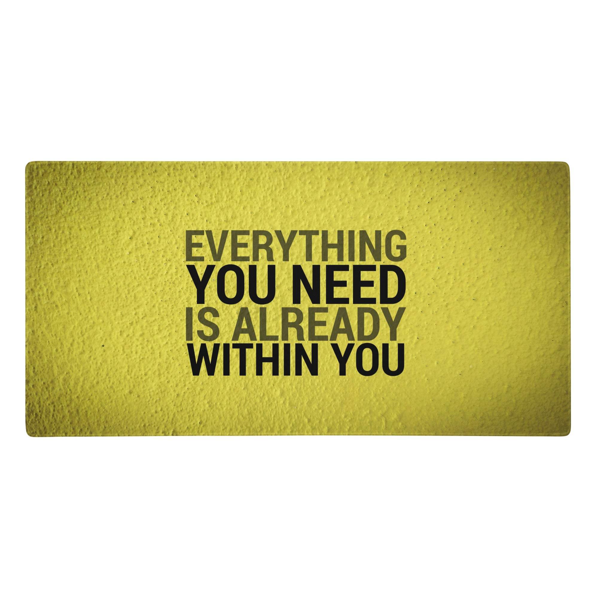 Bold yellow motivational desk pad with textured fabric and black typography reading everything you need is already within you