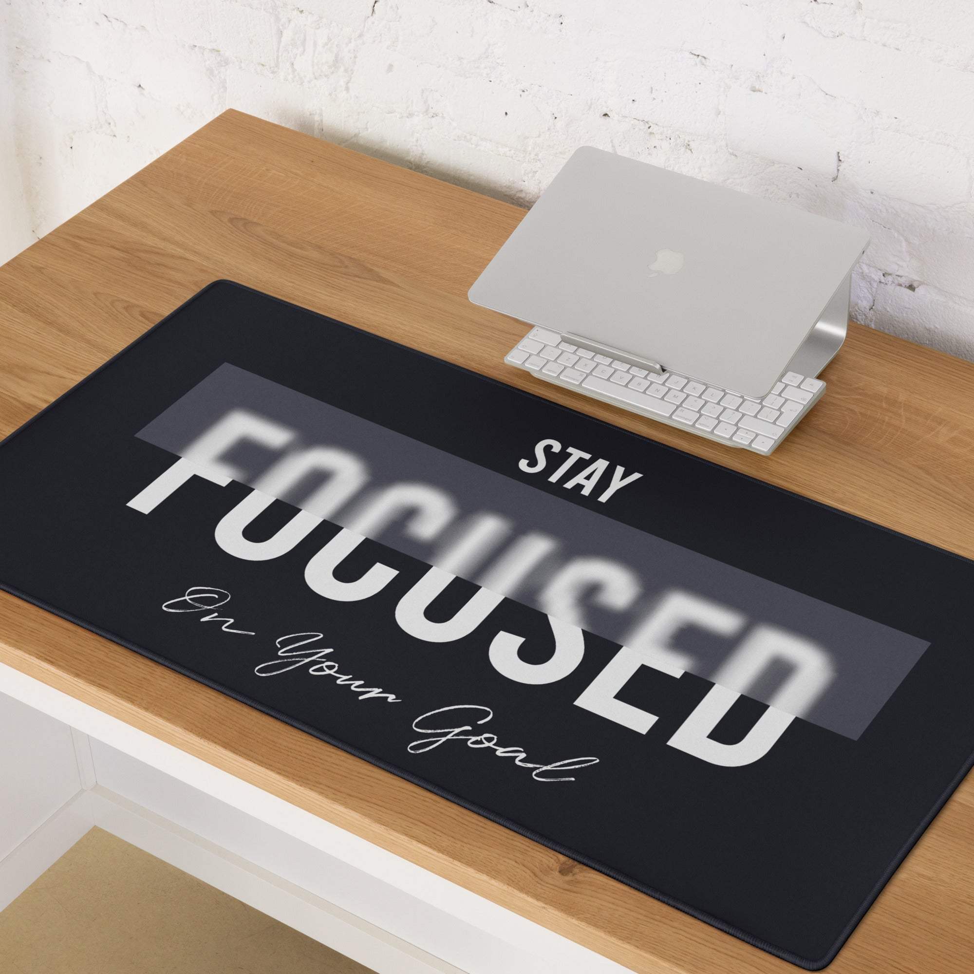 Black rectangular mousepad with bold white motivational text stay focused on your goal and subtle gray gradient design