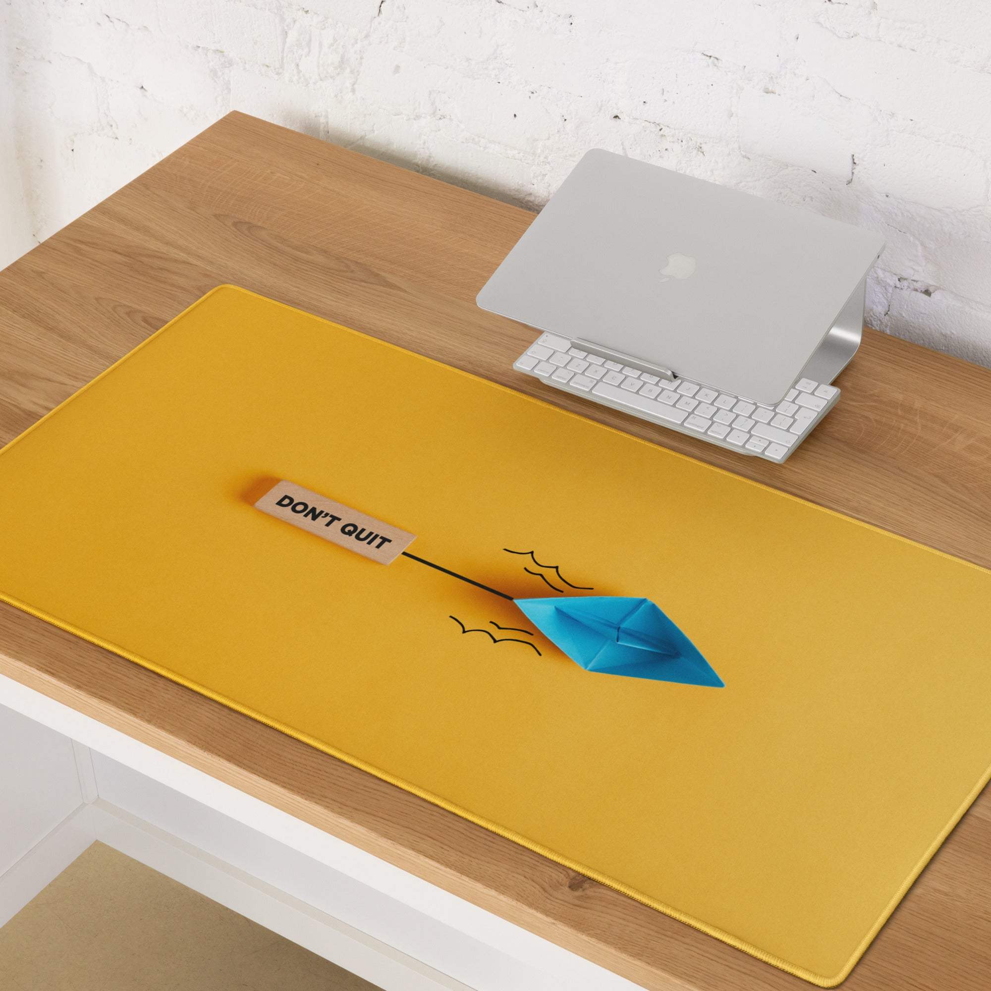 Yellow orange origami boat desk pad featuring a bright yellow rectangular non slip mousepad with a blue paper boat and motivational tag