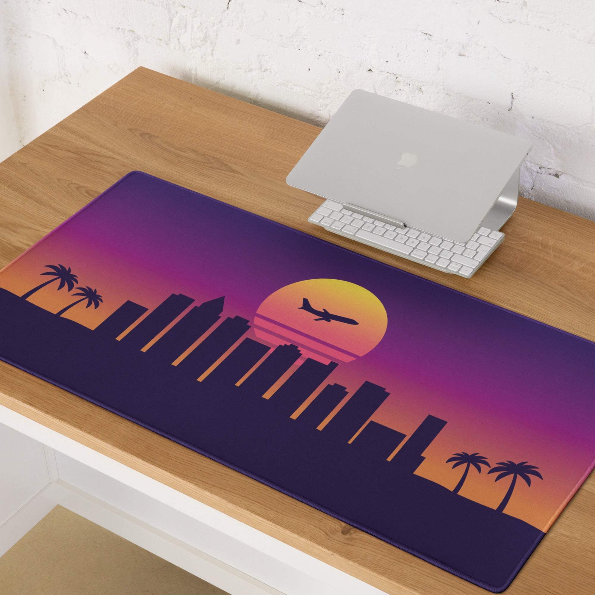 Purple and orange gradient gaming mouse pad with retro city skyline palm trees setting sun and airplane silhouette design