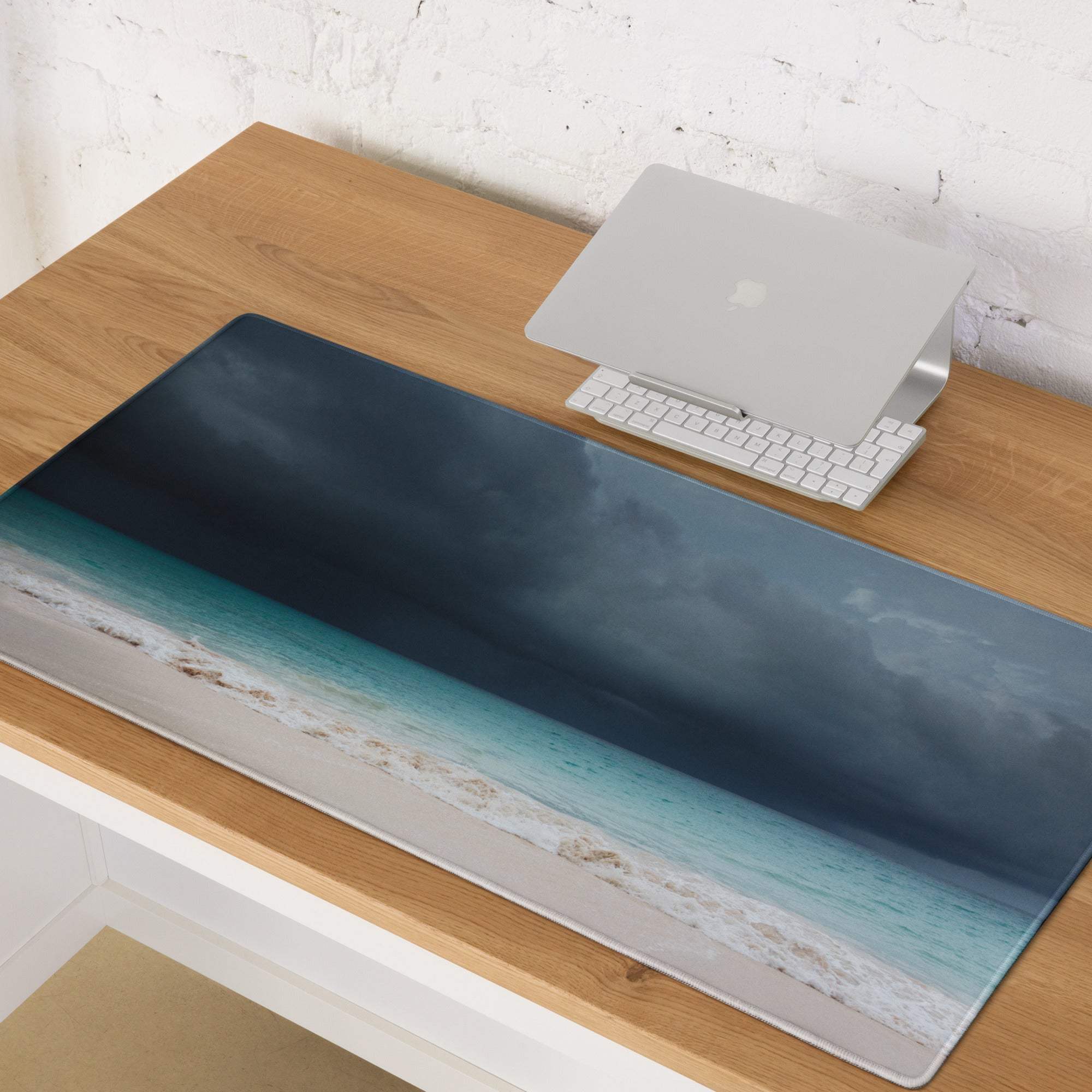 Long rectangular desk mat mouse pad with a stormy ocean vista featuring navy blue teal waves white sand and moody sky