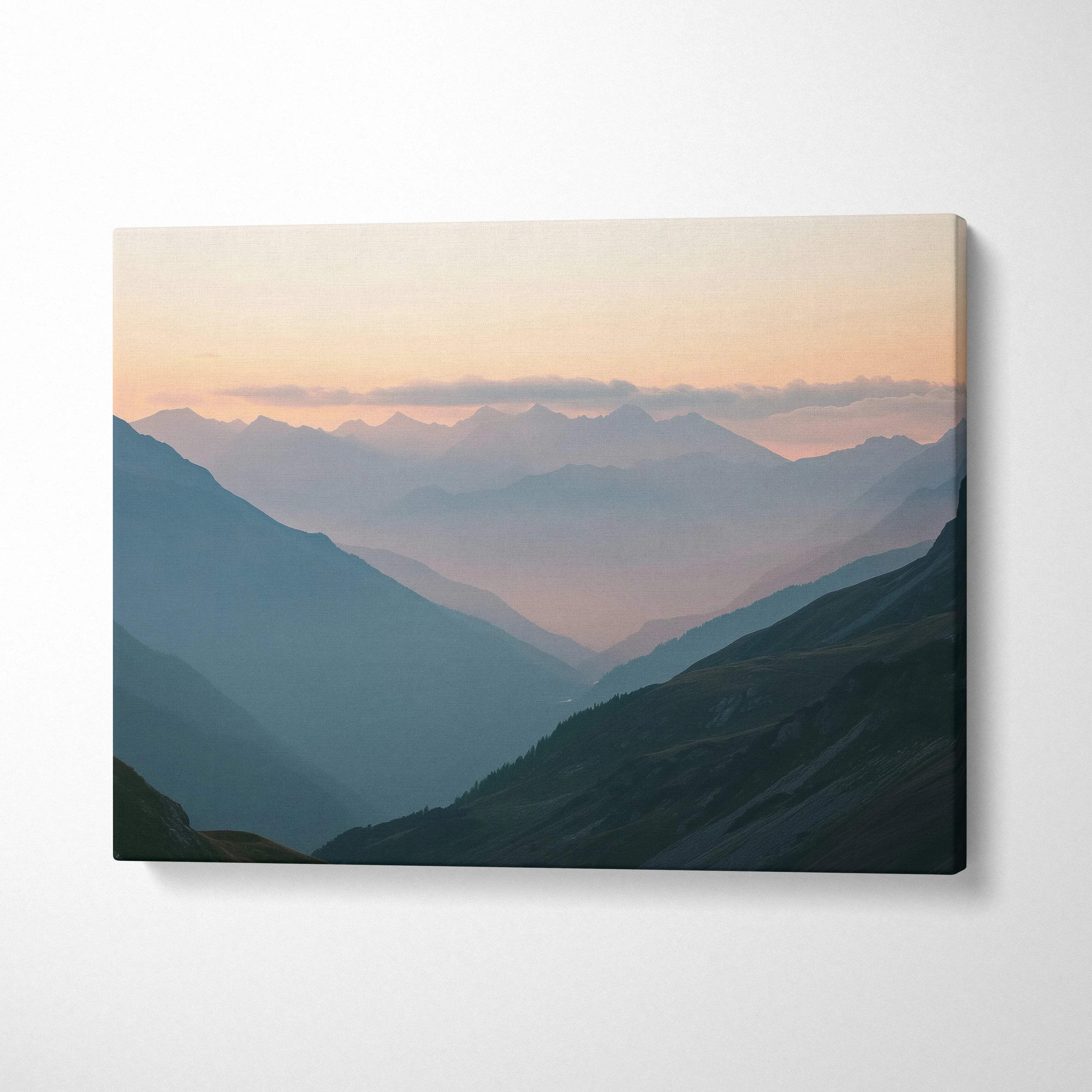 Canvas print of misty mountain valleys at dawn in muted blues, teal shadows, soft peach sky