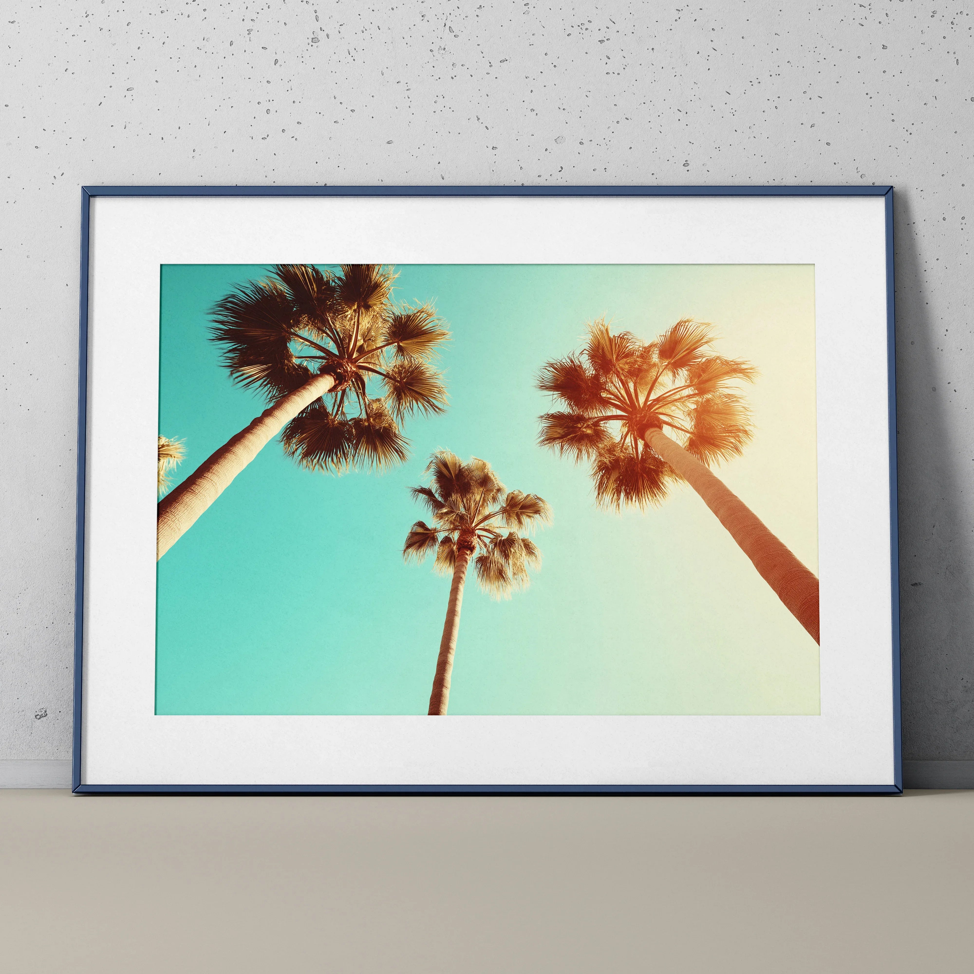 Serene beach poster wall art featuring tall palm trees against a soft blue sky with sunlight glow.