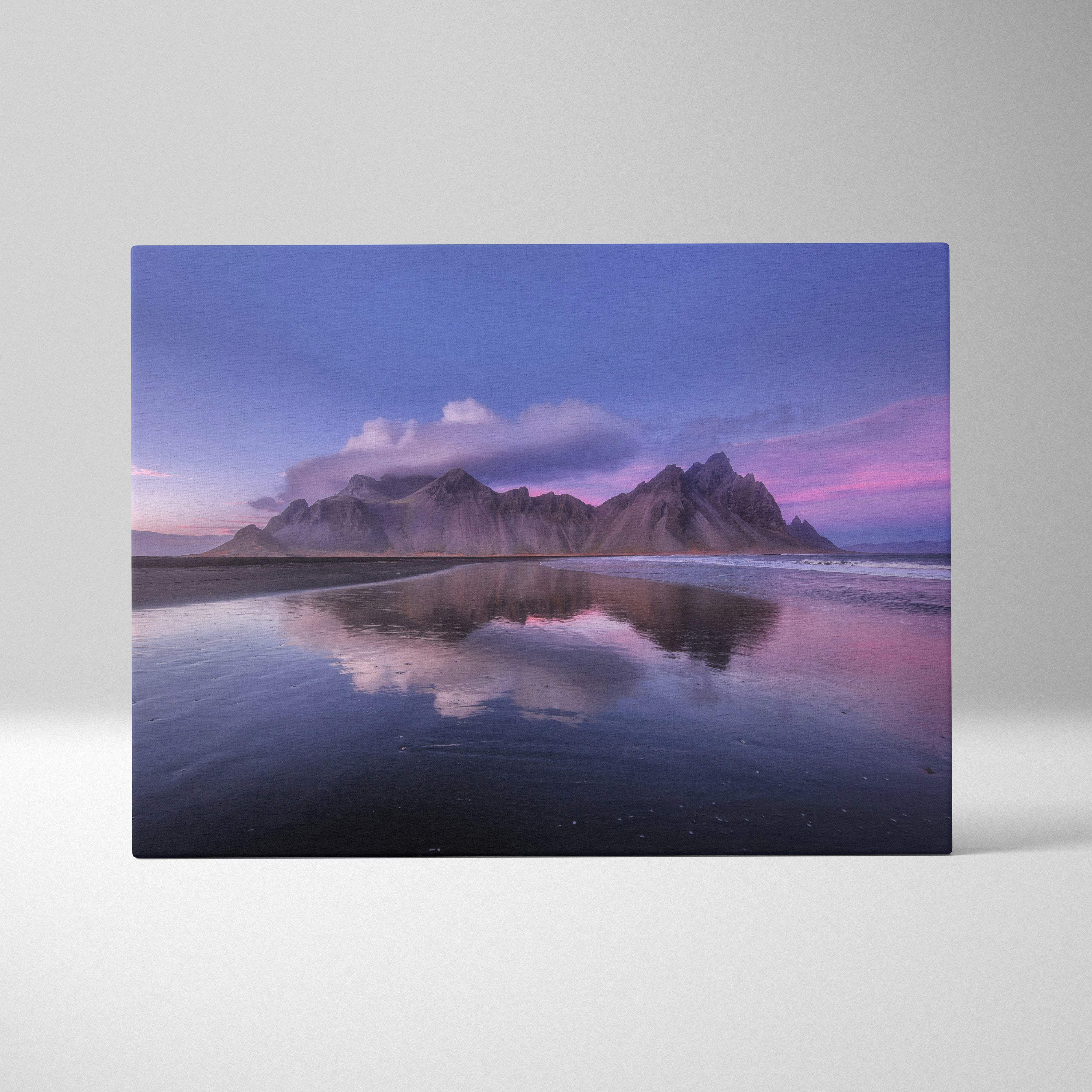 Iceland mountain beach canvas wall art print showing purple sunset reflection of rugged mountains on calm water