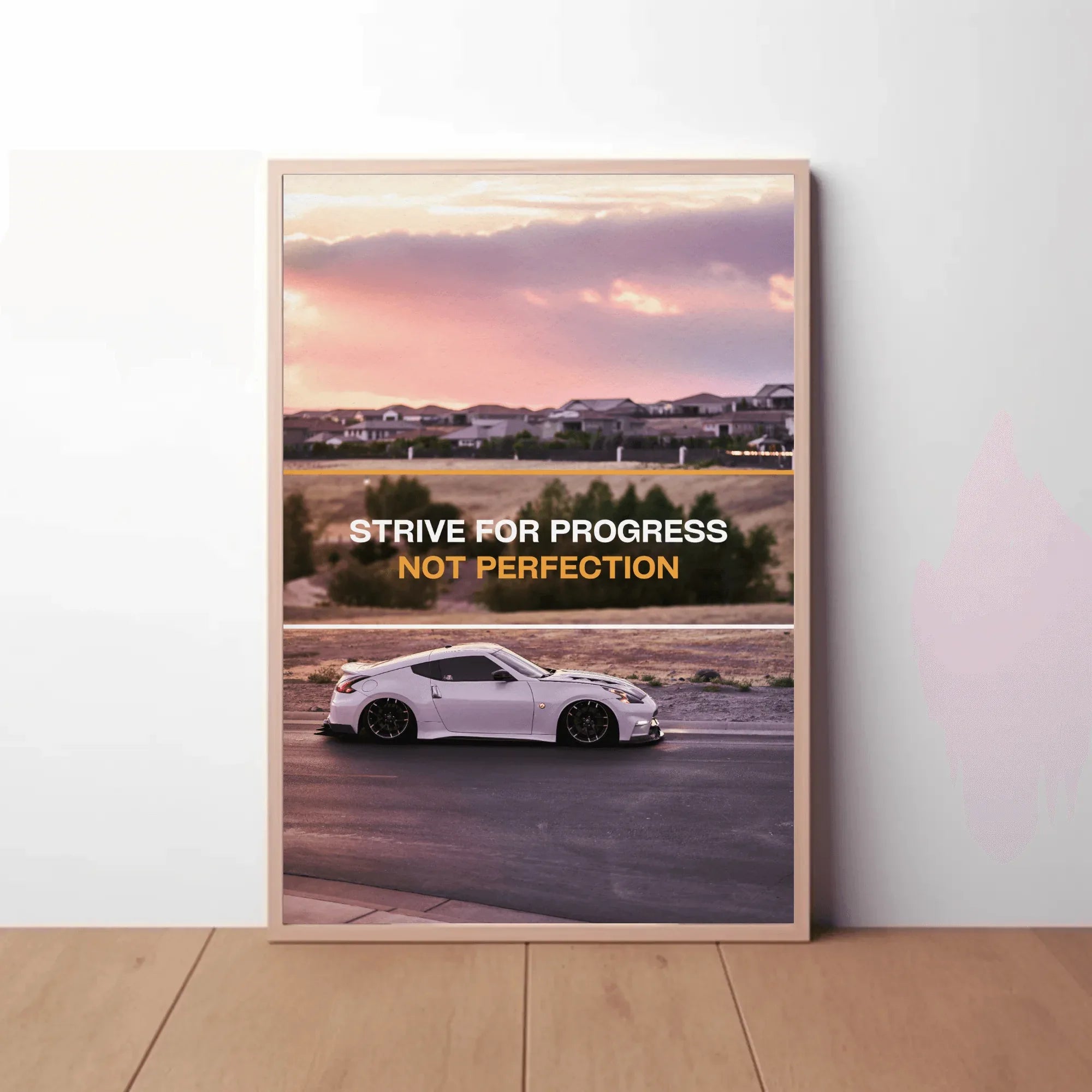 Motivational poster wall art featuring white Nissan 370z with text "Strive for progress not perfection" against sunset.
