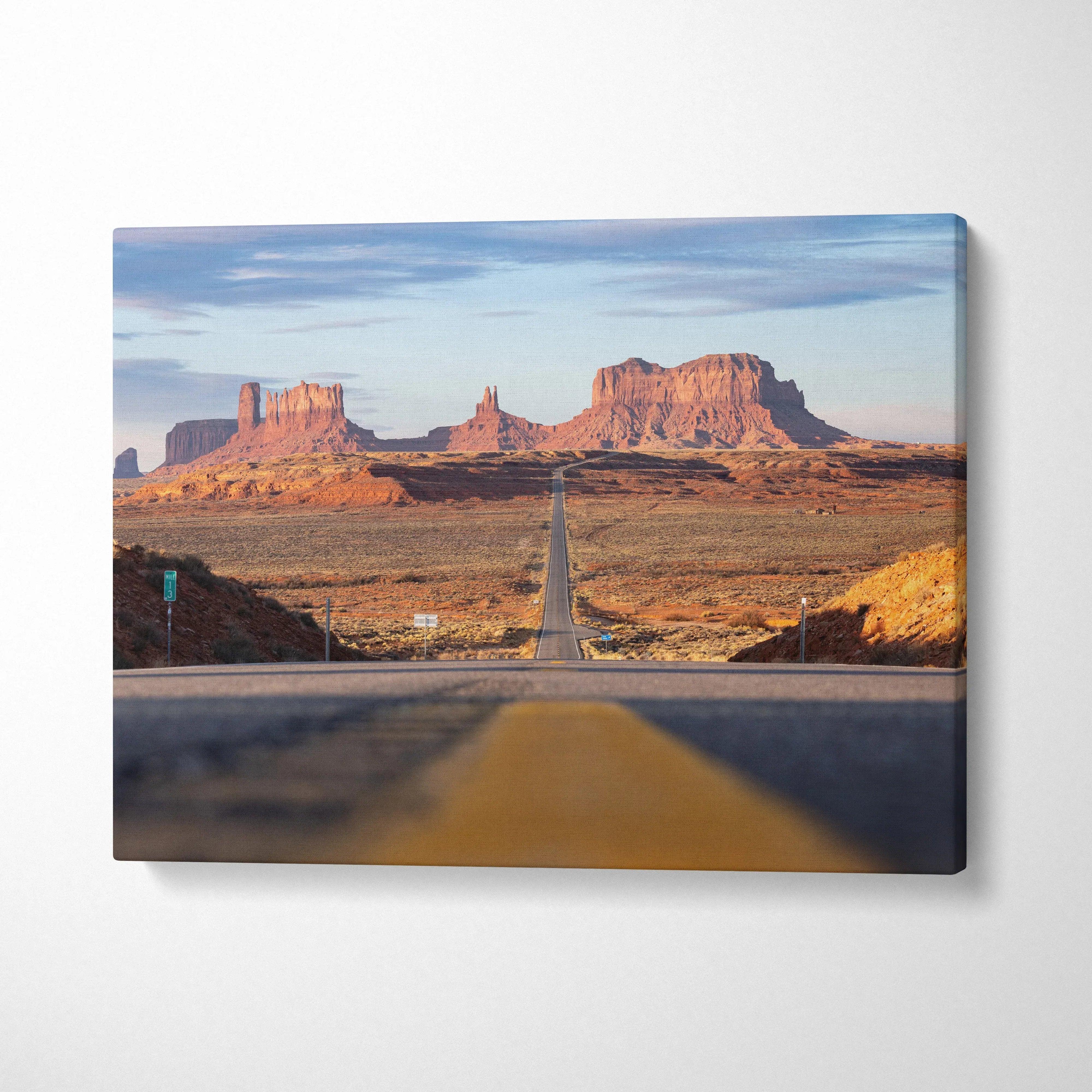 Desert landscape with red rock formations and a long road on canvas wall art print.