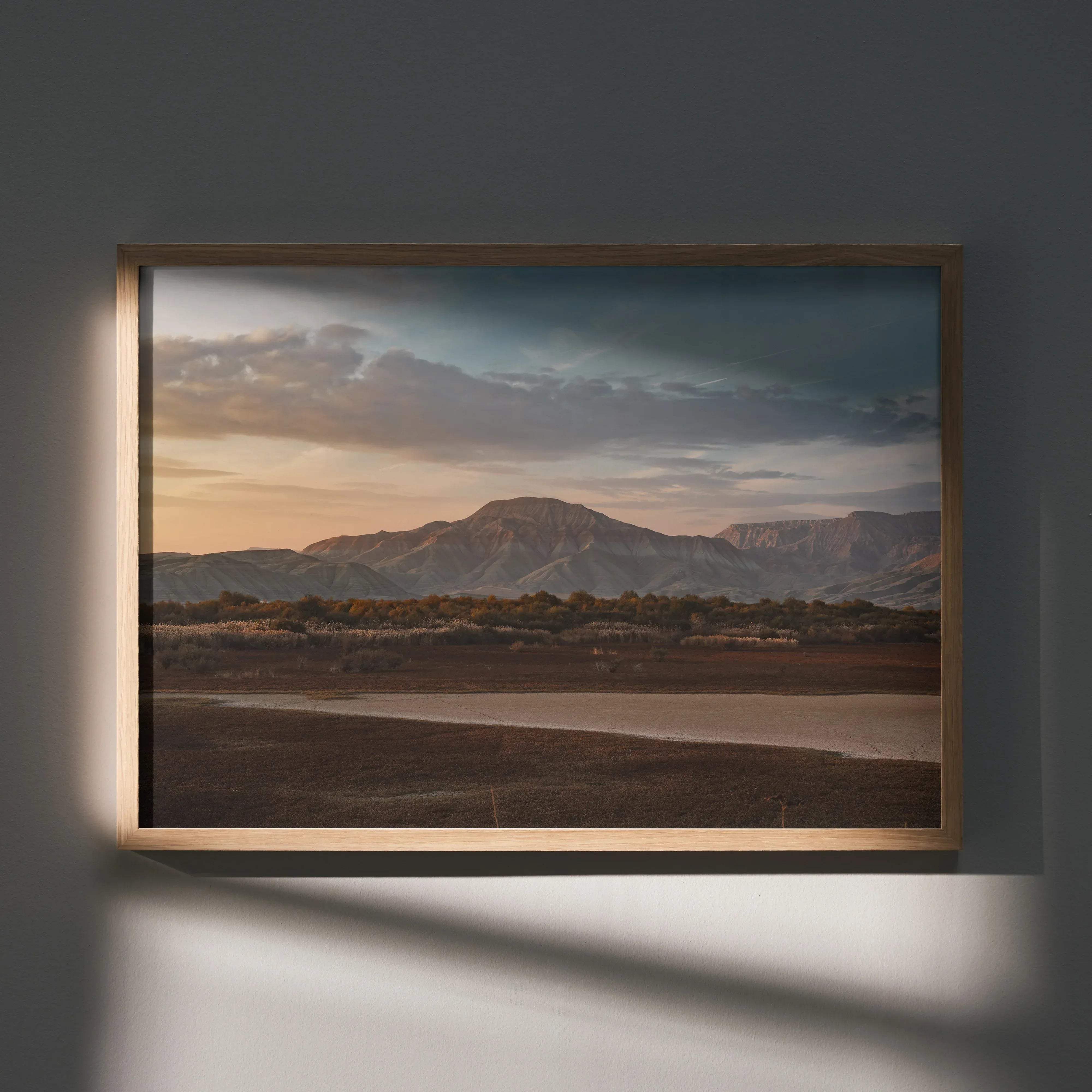 Majestic mountain wall art poster featuring a warm-toned landscape in a thin light wood frame for home decor