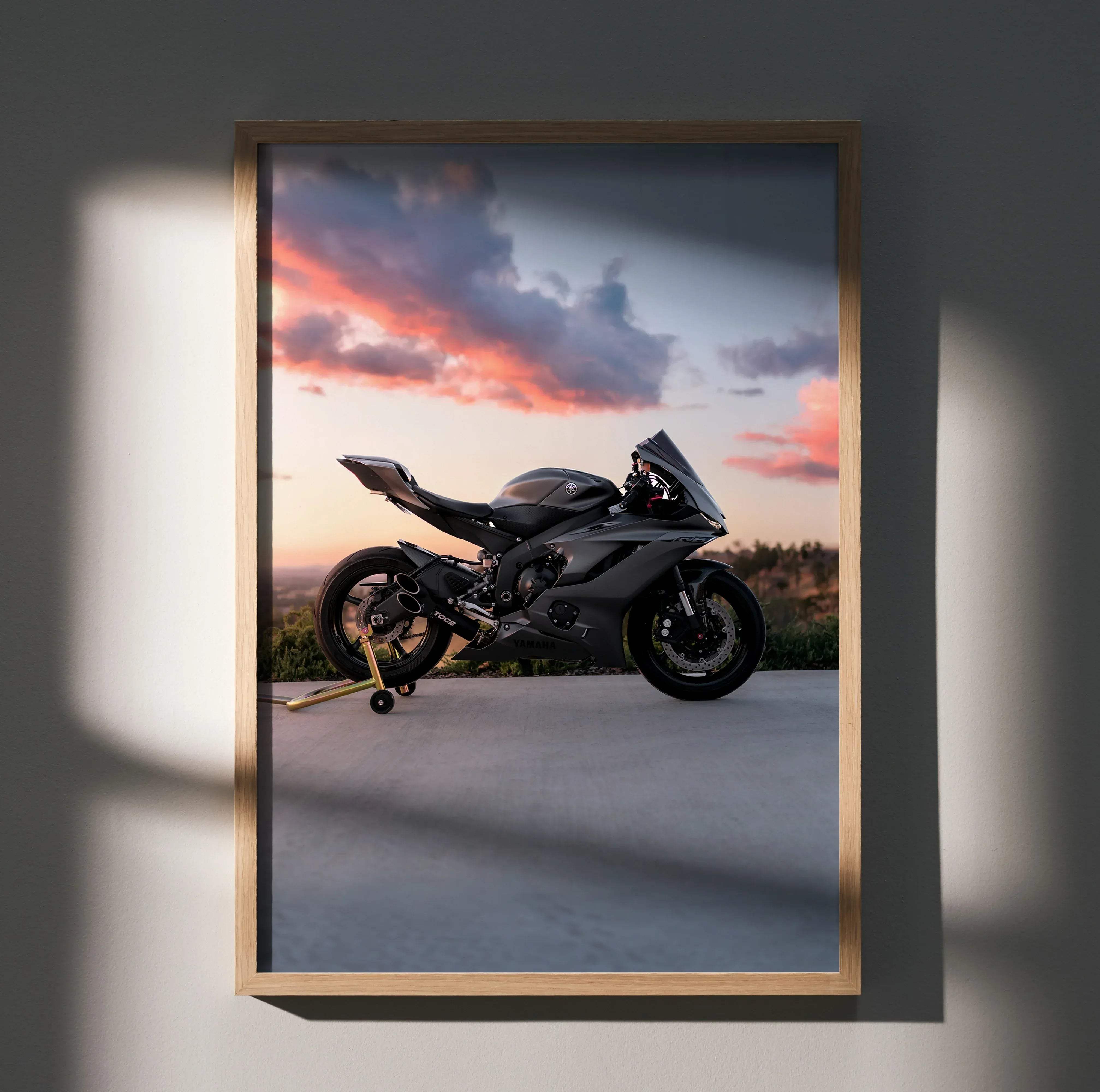 A sleek black yamaha r6 motorcycle poster framed in light wood featuring the bike against a sunset sky