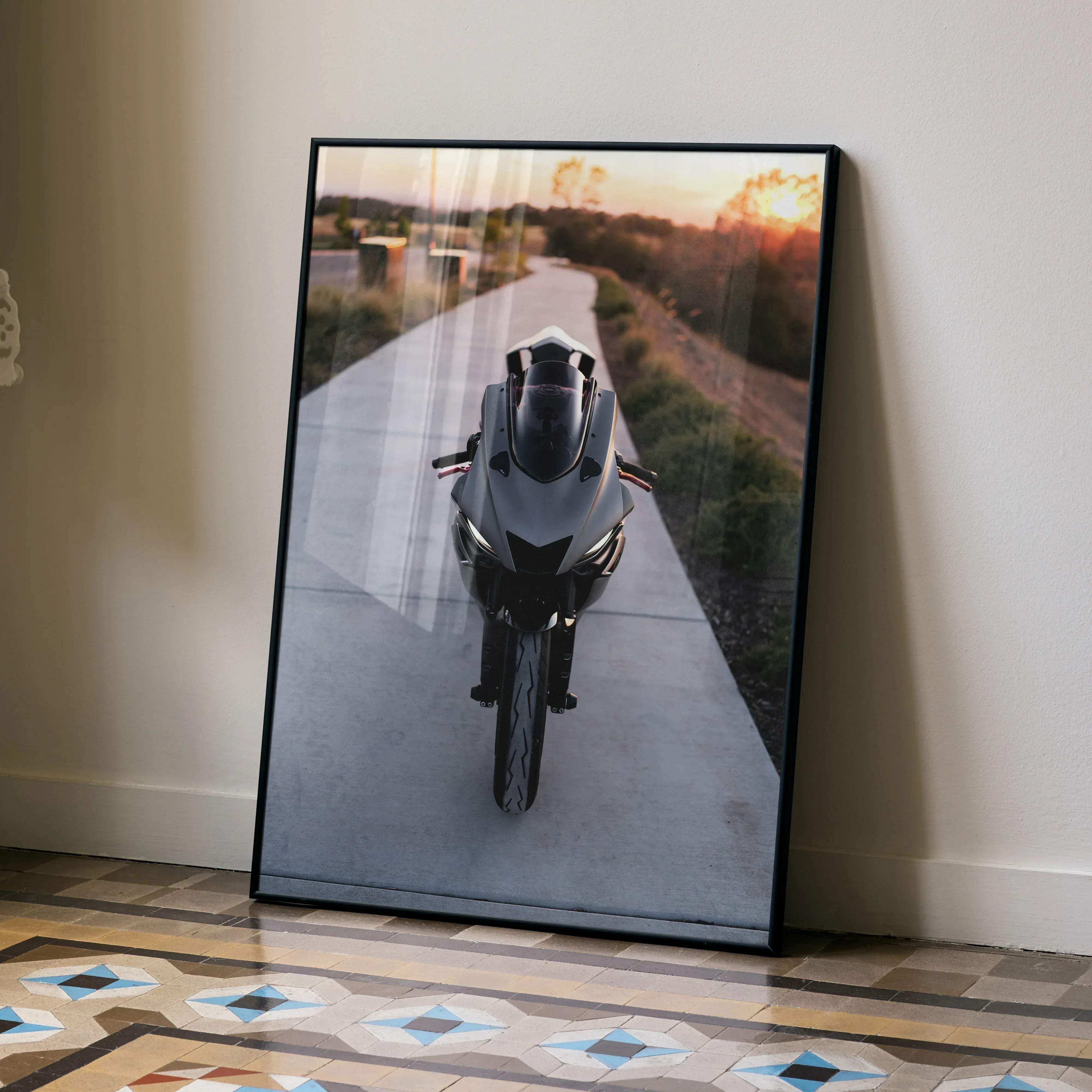Black-framed poster of sleek matte black Yamaha R6 sport motorcycle photographed from front on paved road at sunset
