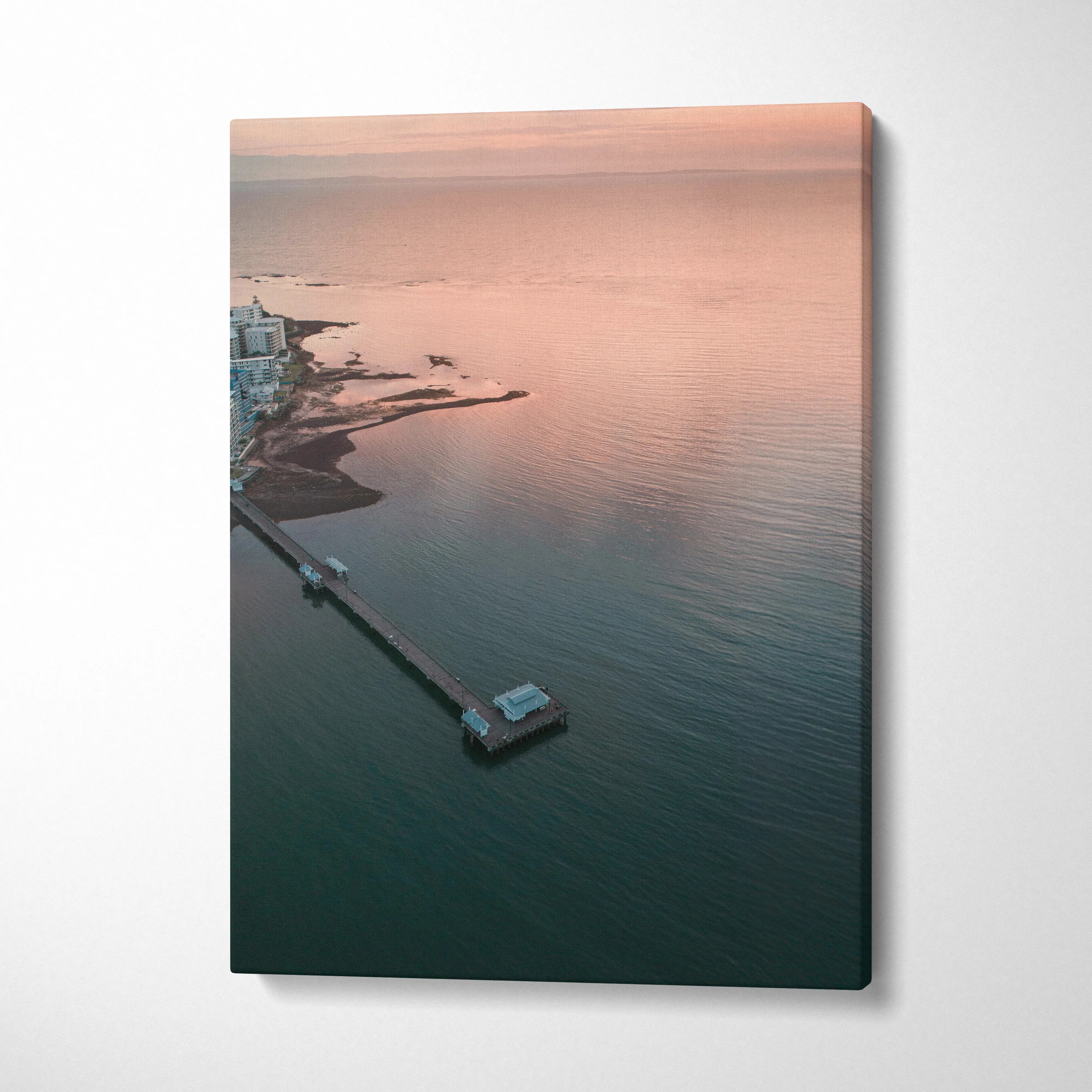 Ocean sunset beach scene with pier and soft pastel sky on canvas wall art.