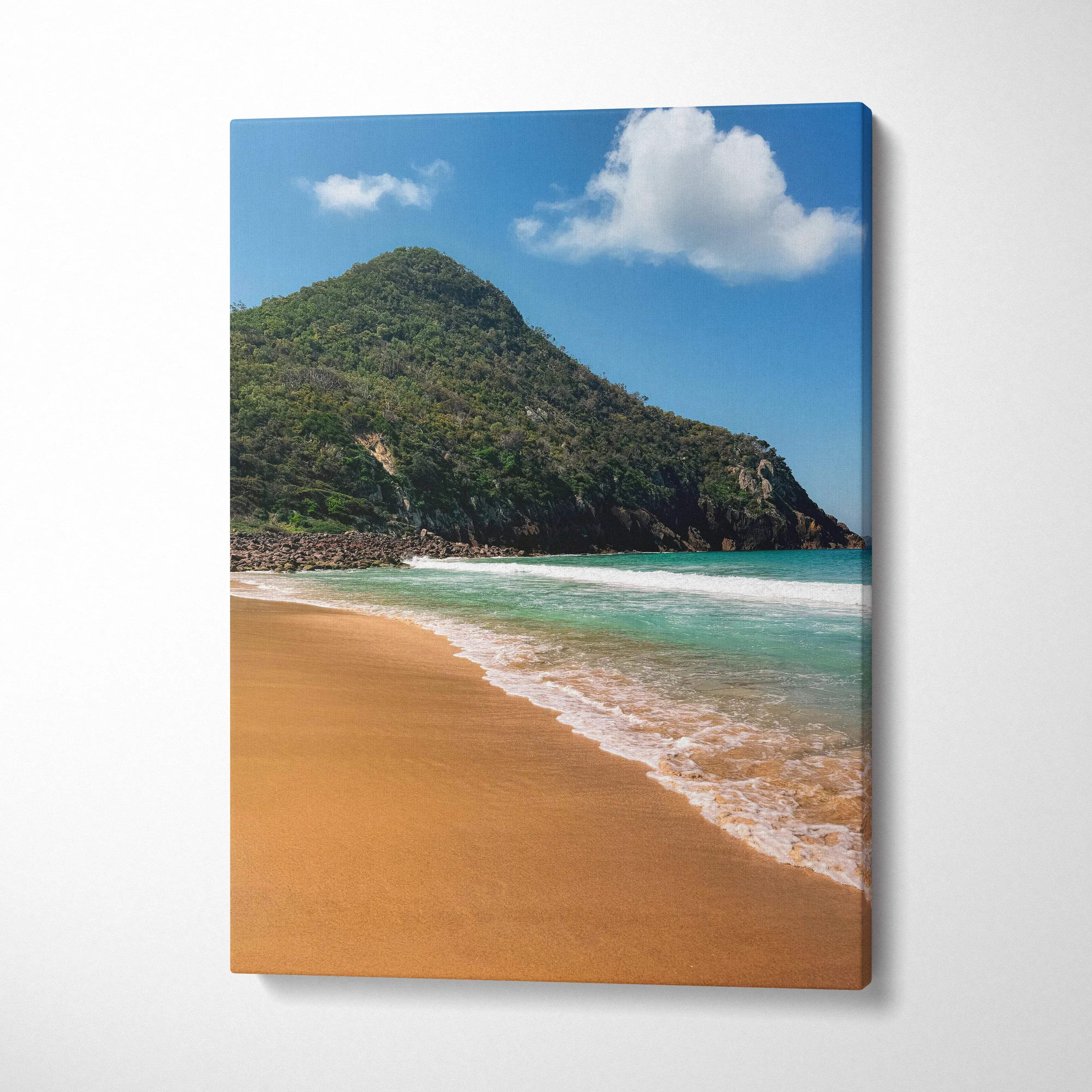 Vertical canvas wall art of a sunny beach with turquoise waves and a green mountain under blue sky.