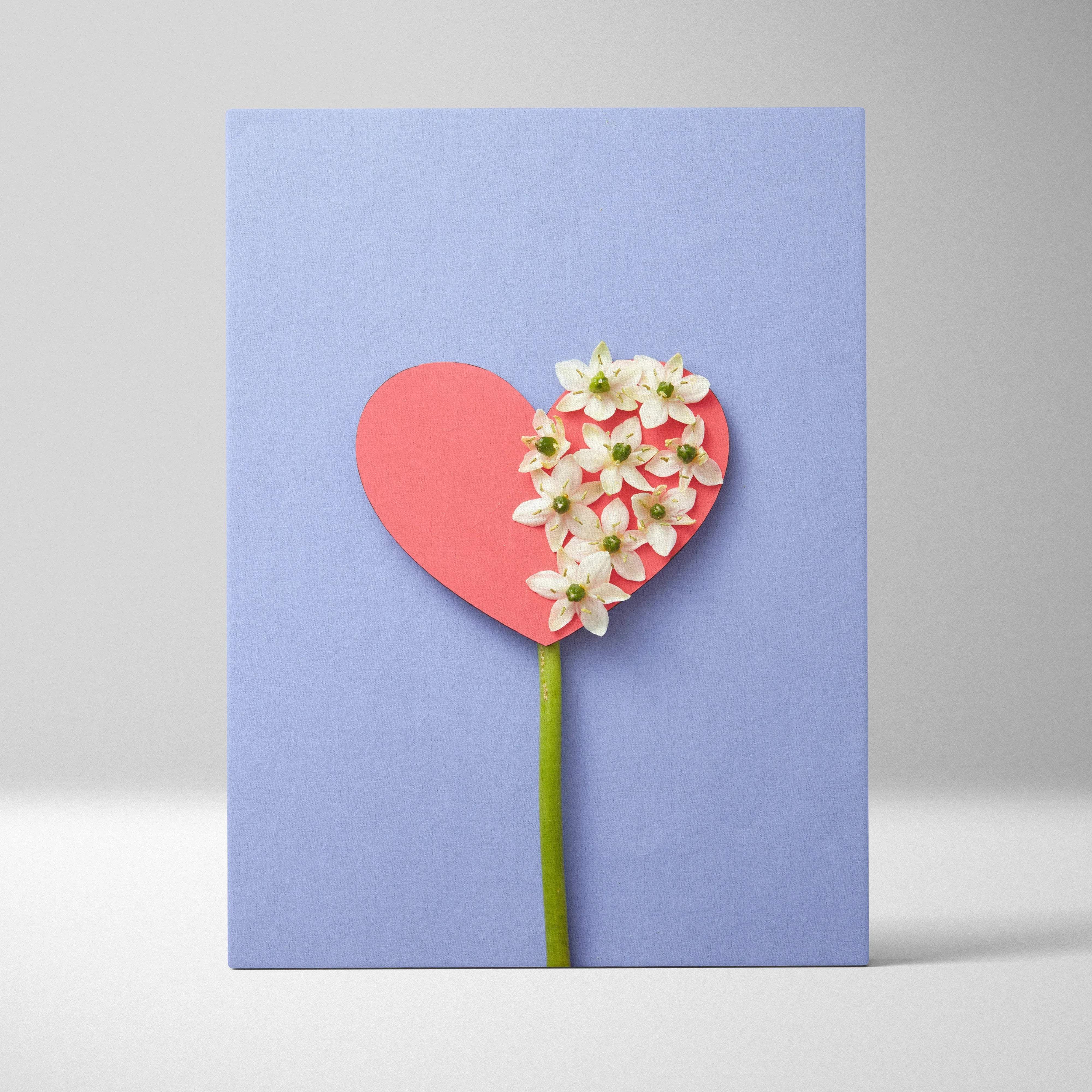 Pastel blue heart canvas wall art with white flowers on coral paper, lavender background