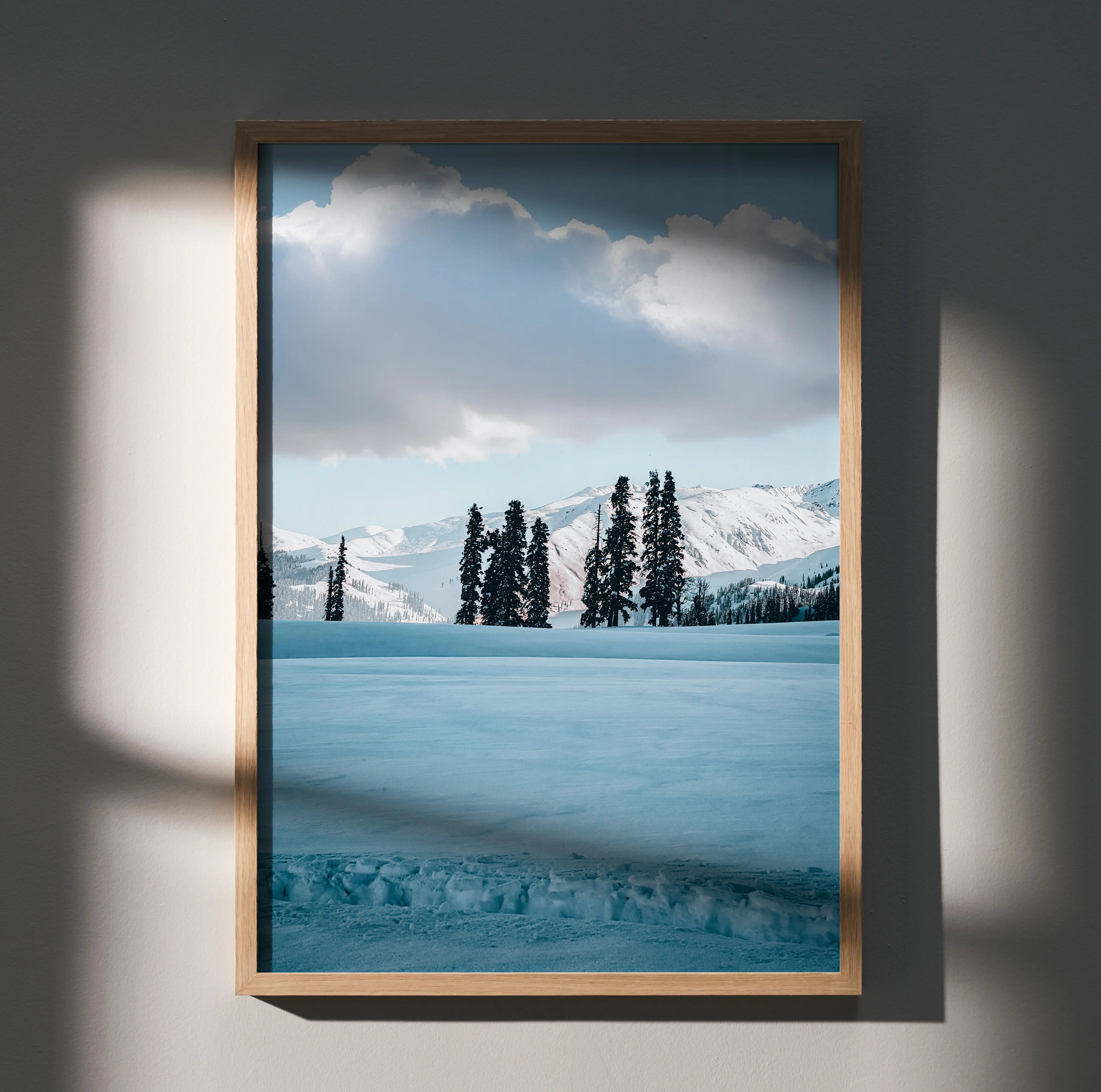 Vertical poster wall art featuring snow-capped mountains with pine trees under a cloudy sky.