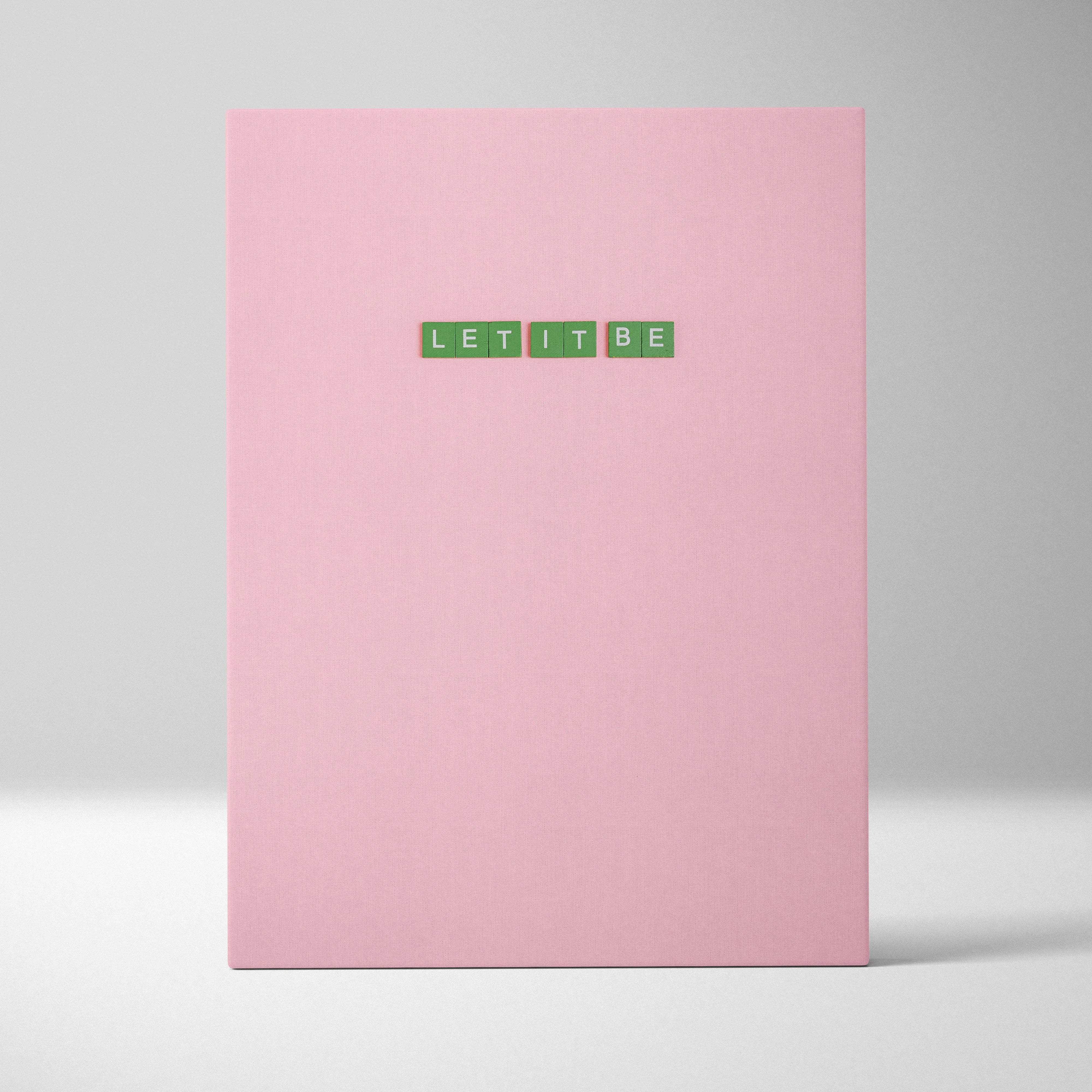 Pink hardcover notebook with green Let It Be tile letters on cover