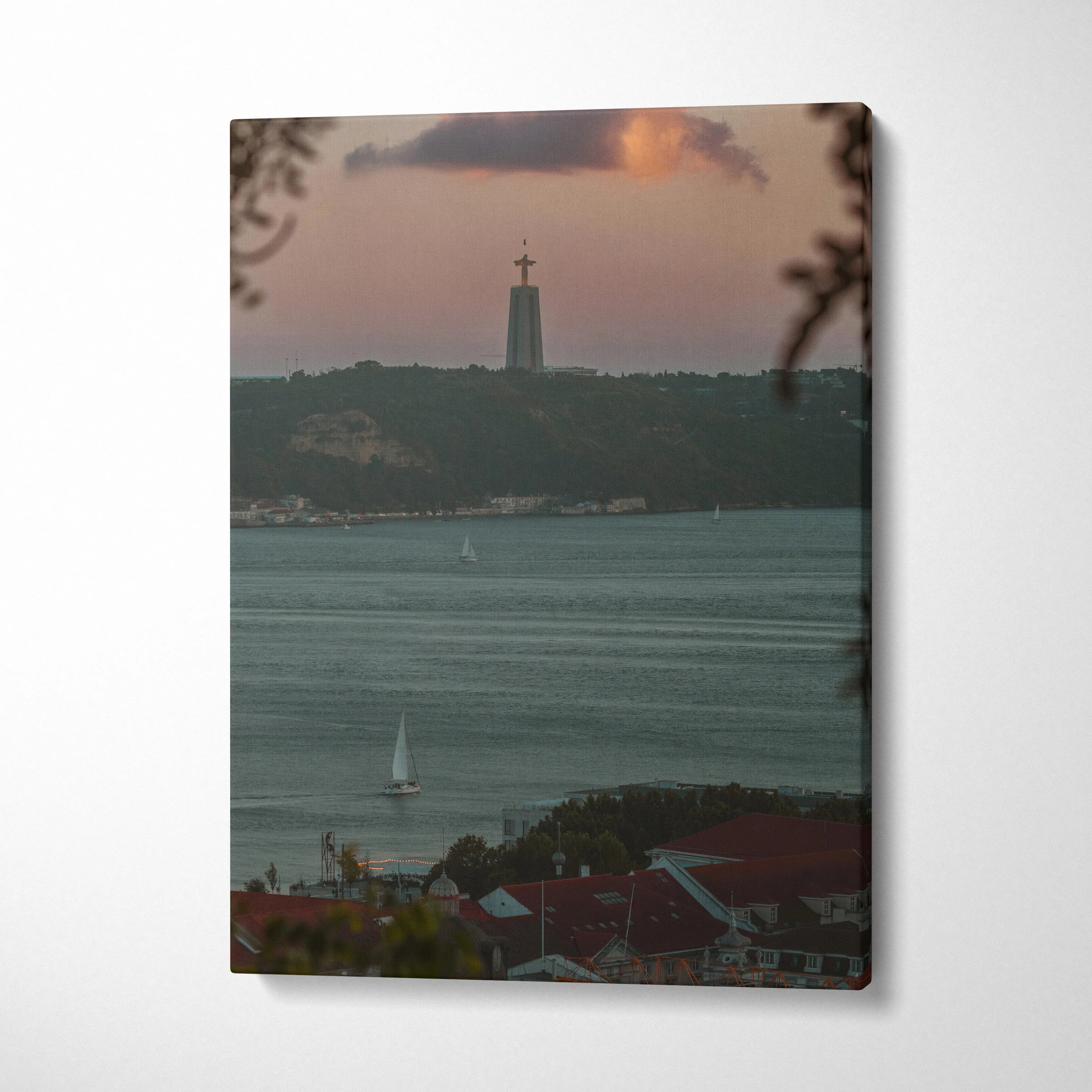 Sunset city skyline canvas wall art featuring a tall tower and sailboat on water.