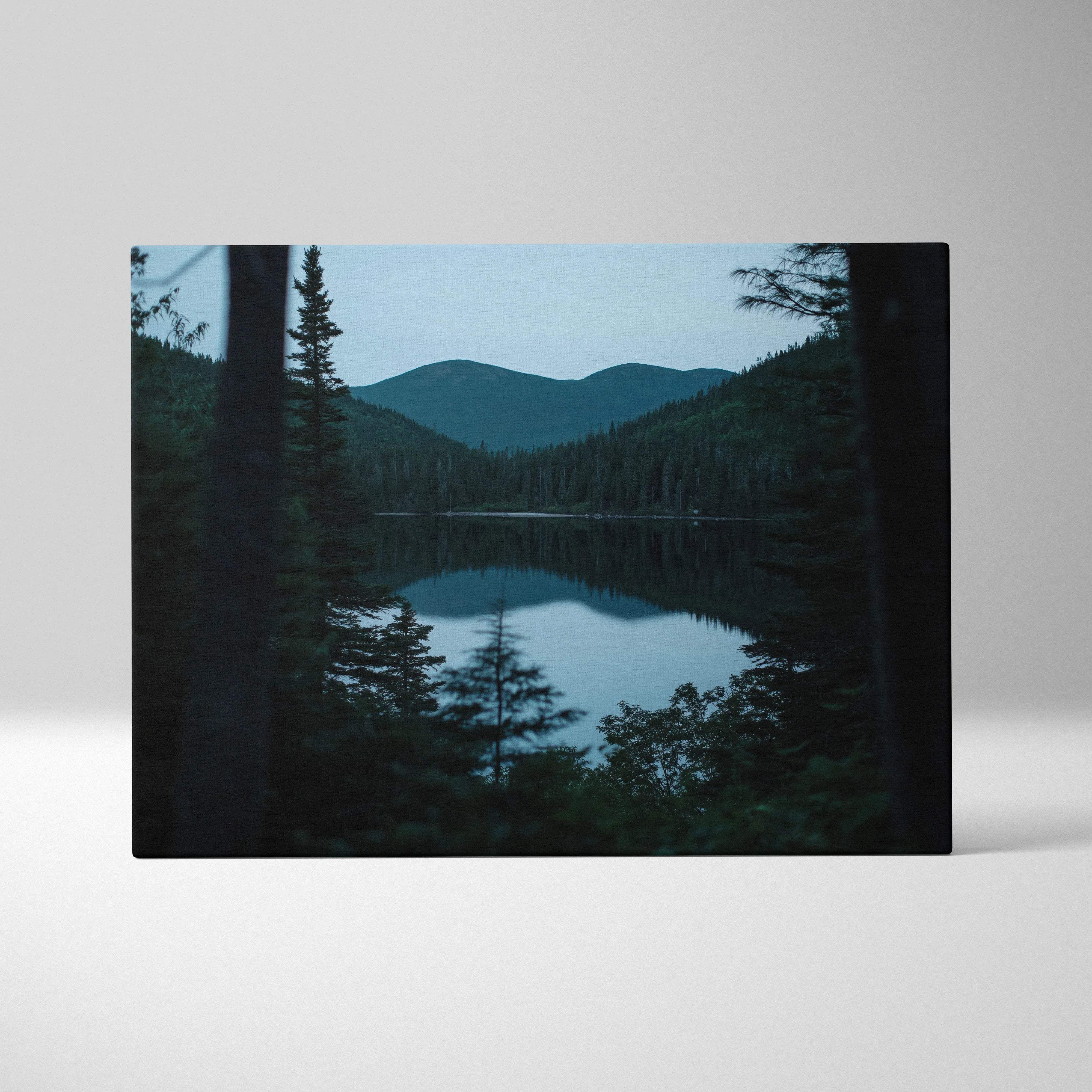 Canvas print of serene lake with evergreen trees, mountains at blue hour