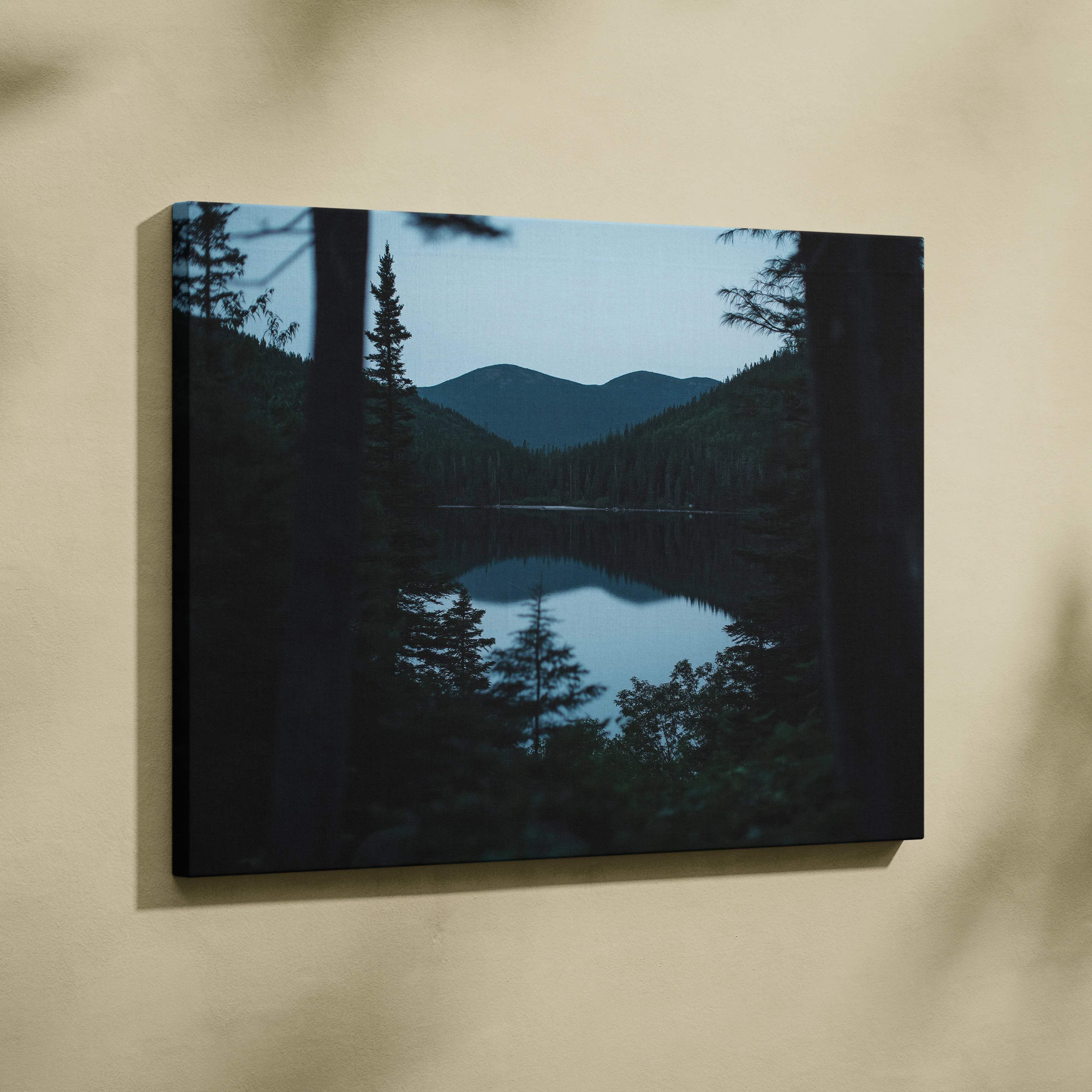 Black-framed canvas print of serene mountains behind forest lake at blue hour