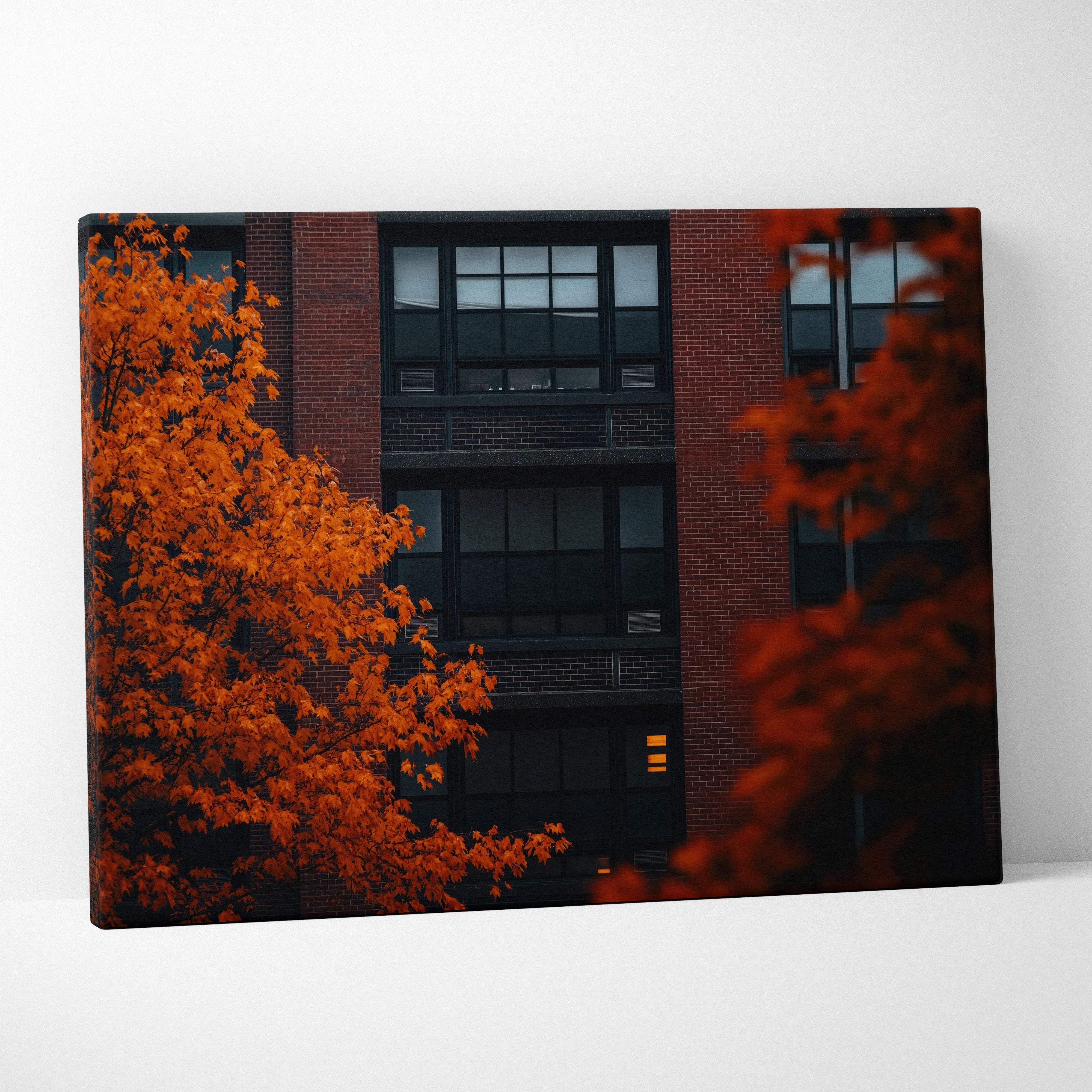 Minimalist autumn urban scene canvas print featuring a brick city building framed by vibrant orange leaves in warm tones