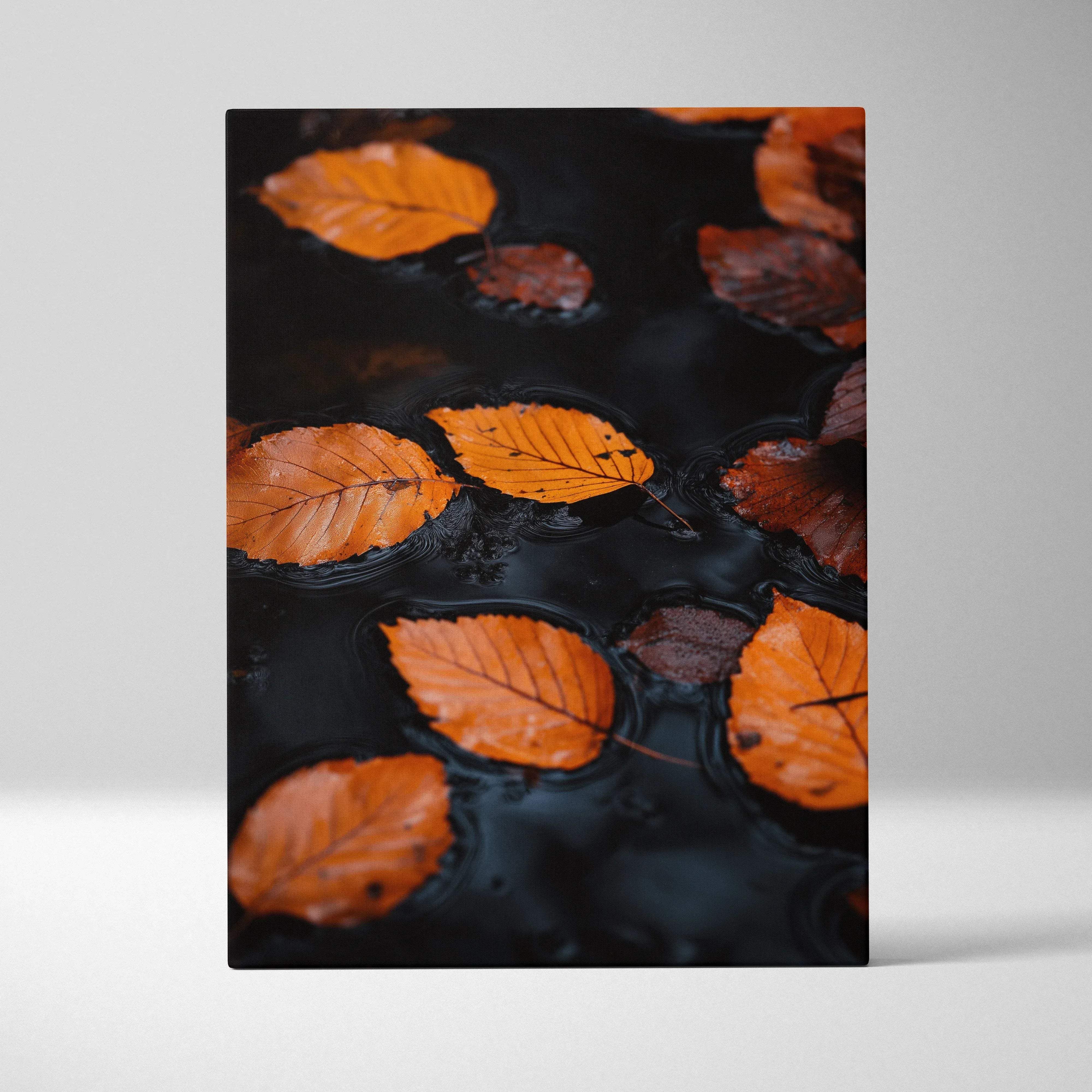 A rectangular canvas wall art featuring vibrant orange and brown autumn leaves floating on dark reflective water