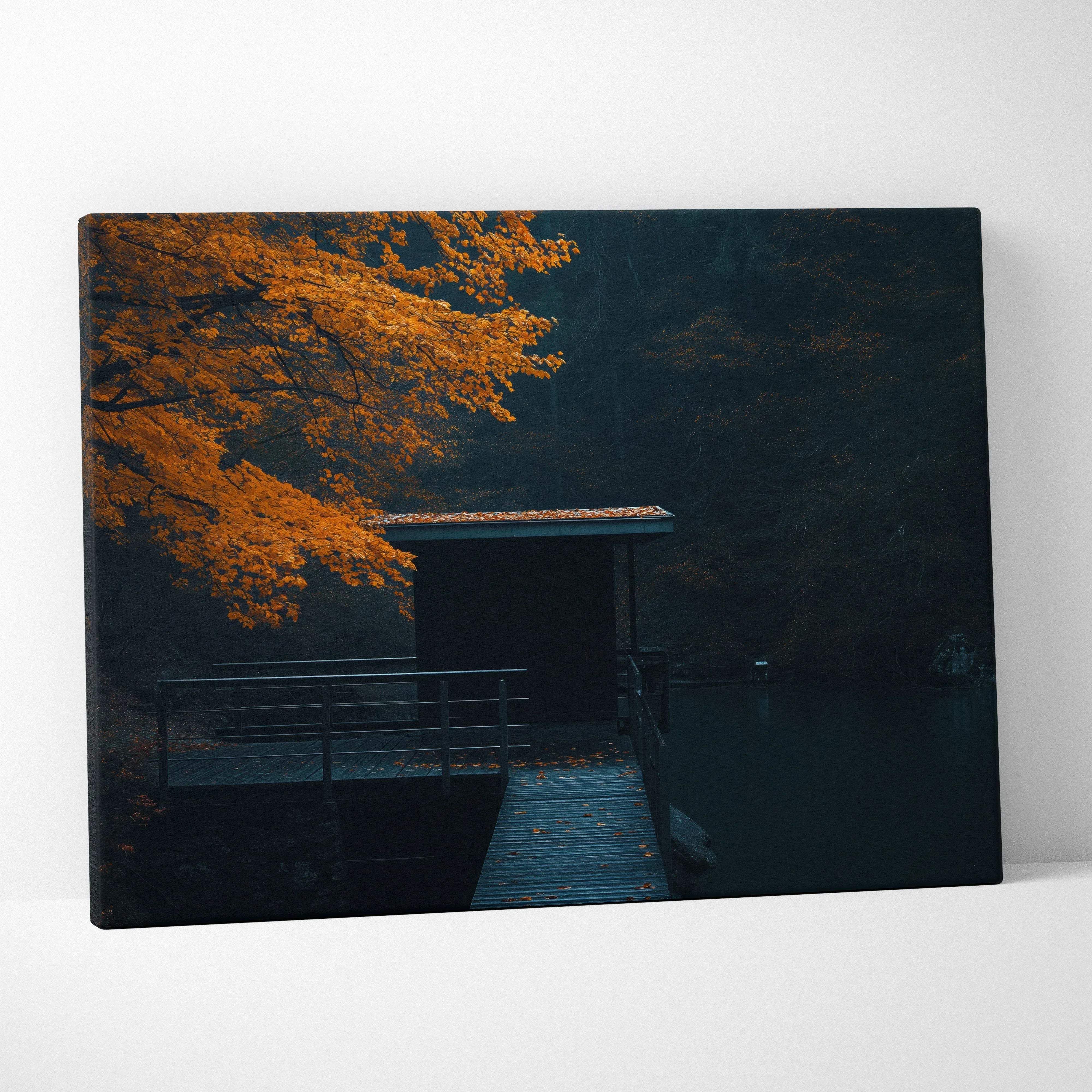 Minimalist autumn lakeside scene canvas wall art with warm orange foliage arching over dock to cabin by water