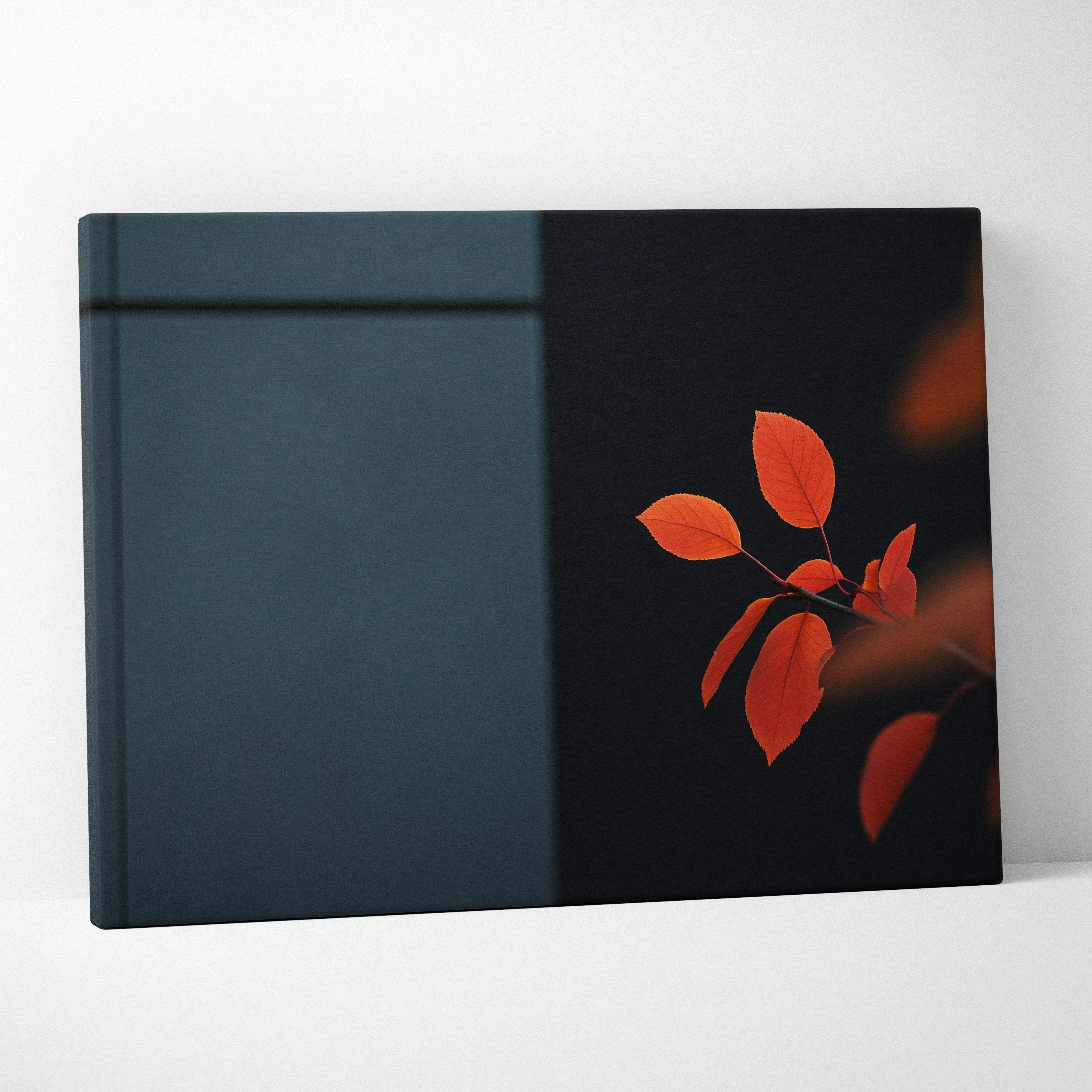 A rectangular canvas wall art print with warm orange autumn leaves on a dark teal and black minimalist backdrop